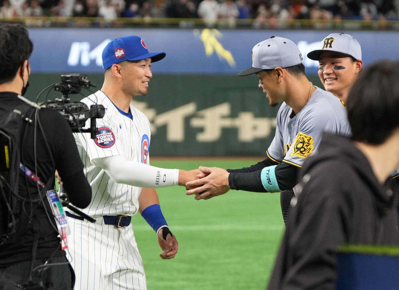 阪神対カブス　試合後の記念撮影を終え談笑する、左からカブス鈴木、阪神佐藤輝、森下（撮影・小沢裕）