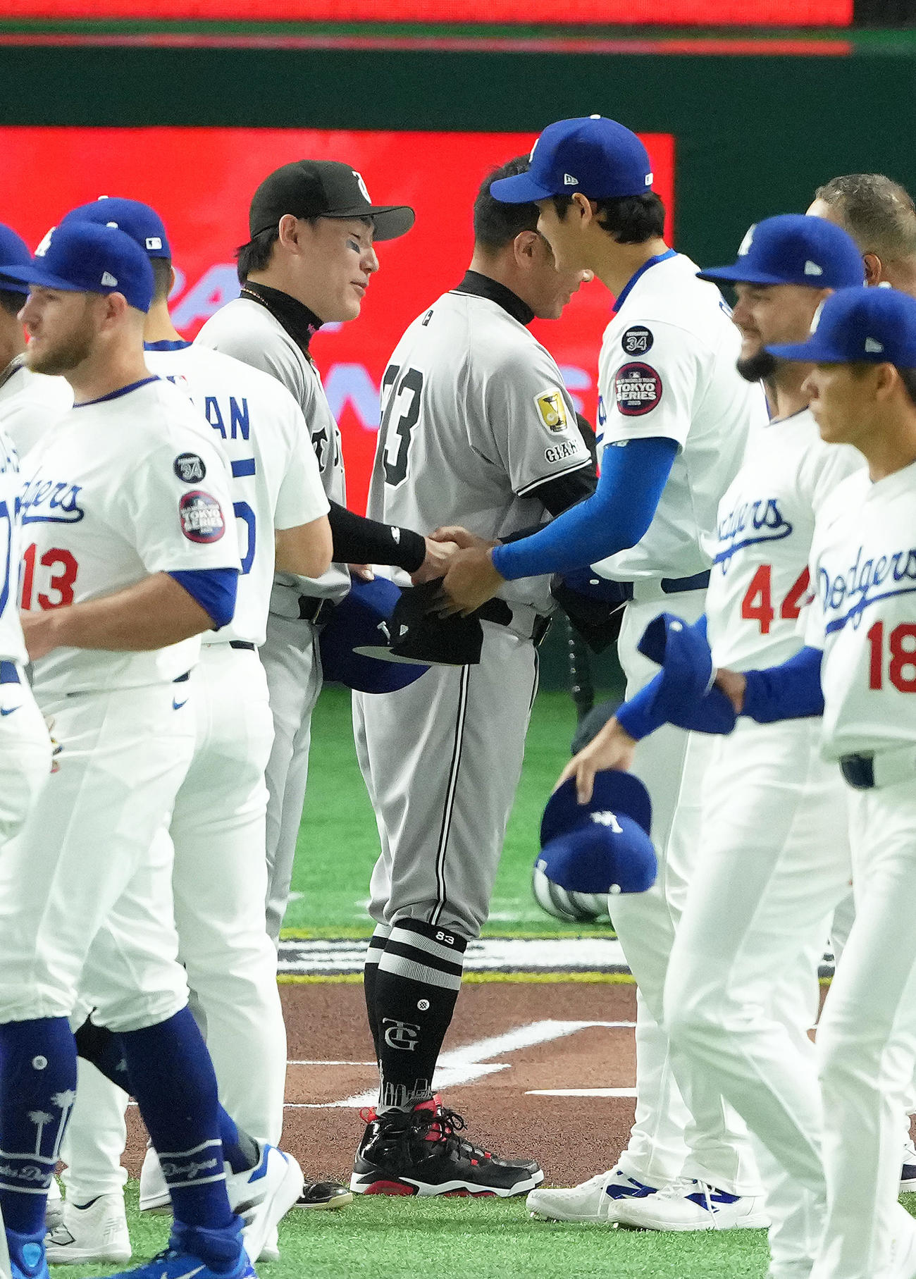 巨人対ドジャース　試合前、帽子を交換し握手を交わすドジャース大谷（右）と巨人丸（撮影・足立雅史）