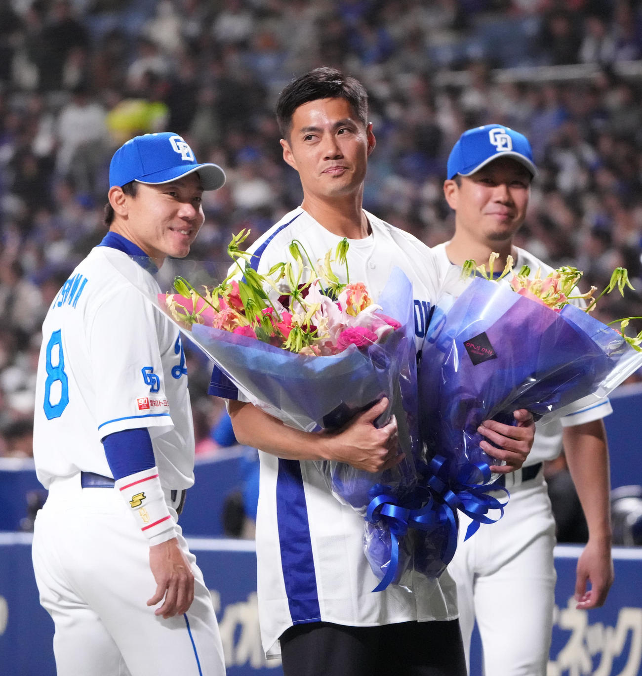 中日対西武　試合前、セレモニアルピッチ後、大野、大島らから花束を受け取るチェン・ウェイン氏（中央）（撮影・森本幸一）