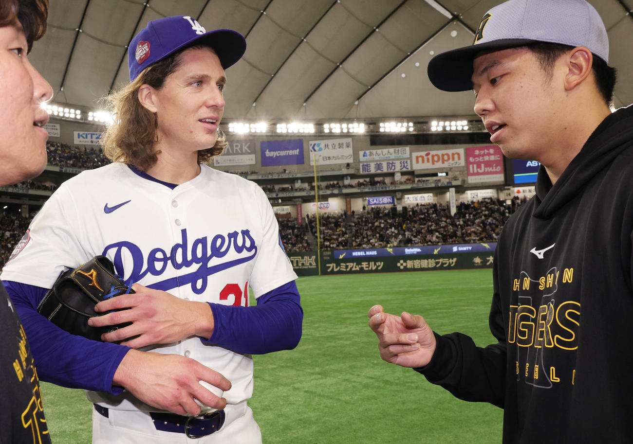 阪神対ドジャース　試合後にボールの握りについて話をするドジャースのグラスノー（左）と阪神才木（撮影・野上伸悟）