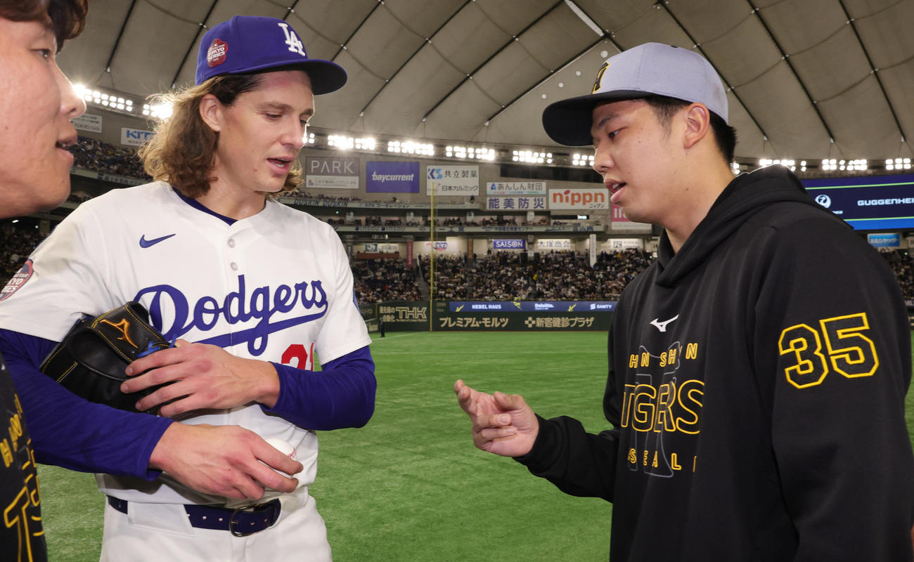 阪神対ドジャース　試合後にボールの握りについて話をするドジャースのグラスノー（左）と阪神才木（撮影・野上伸悟）
