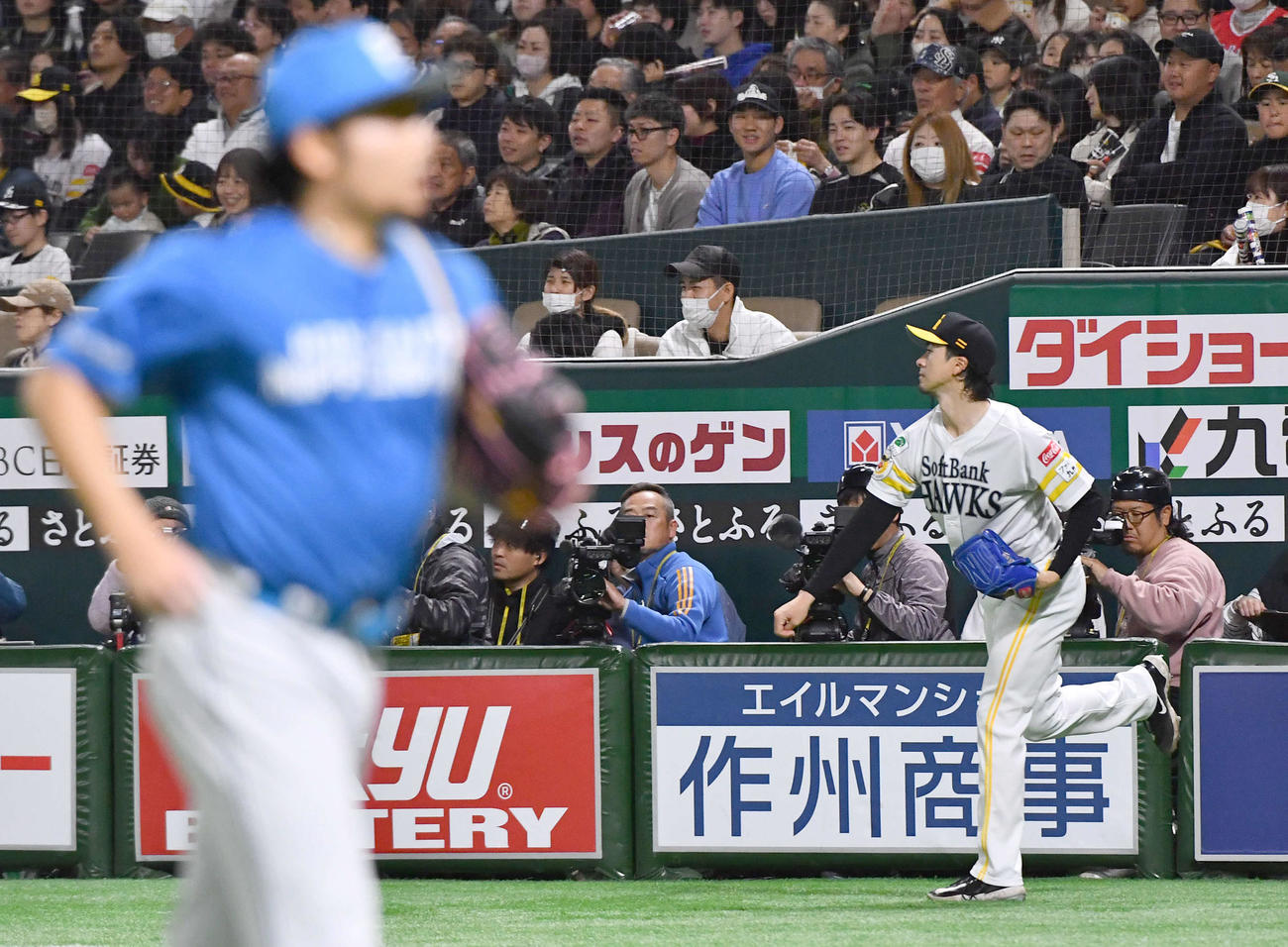 ソフトバンク対日本ハム　1回裏を抑えてベンチへ戻る日本ハム伊藤（左）と、ベンチ前でキャッチボールを行うソフトバンク上沢（撮影・岩下翔太）