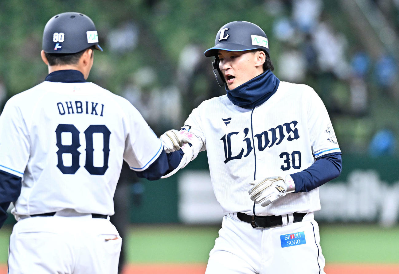 西武対広島　8回裏西武1死、右前打を放った代打元山（右）は大引コーチとタッチをかわす（撮影・滝沢徹郎）
