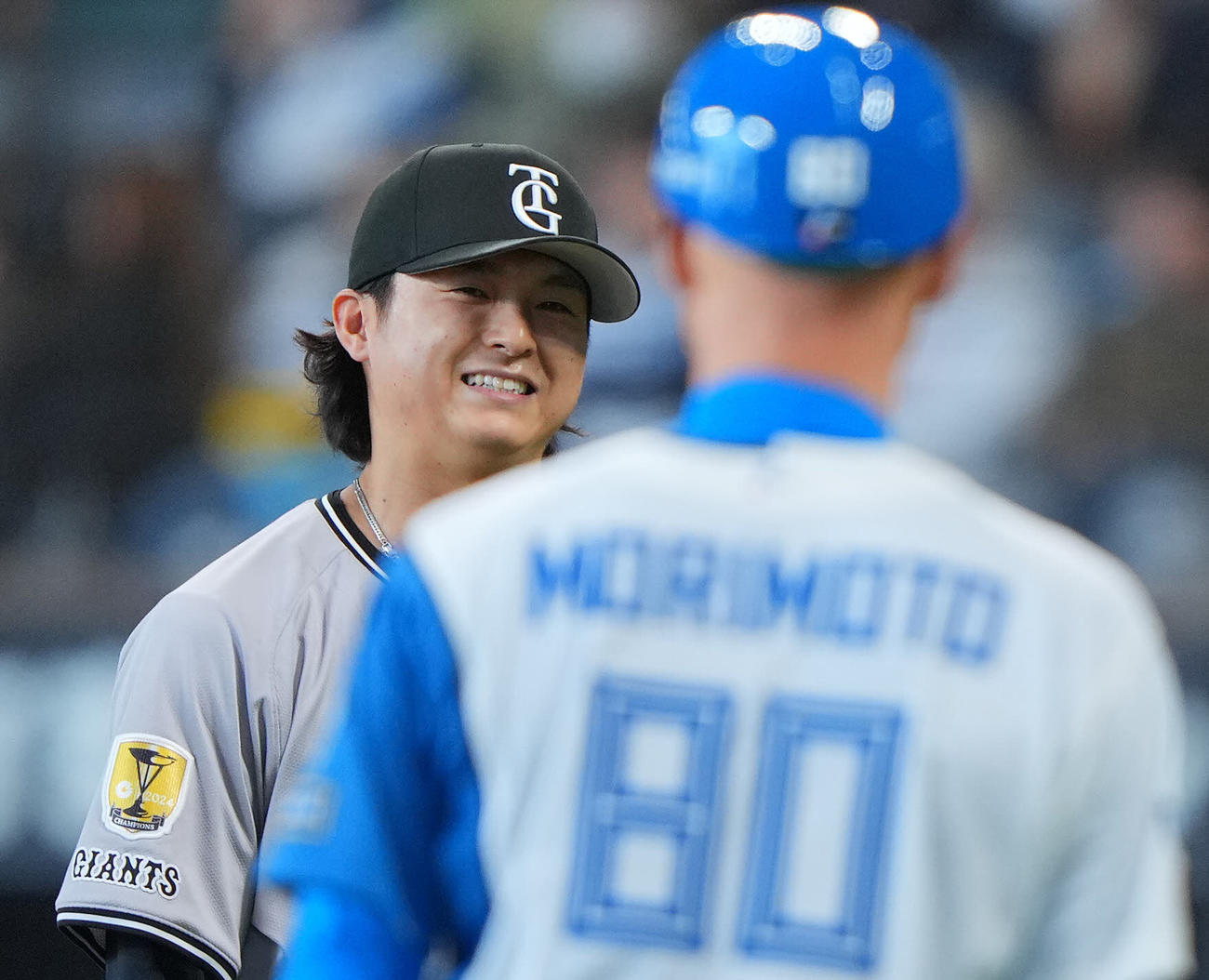 日本ハム対巨人　8回裏日本ハムの攻撃を無失点に抑えた巨人田中瑛は日本ハム森本コーチ（手前）と目を合わせ笑顔を見せる（撮影・垰建太）