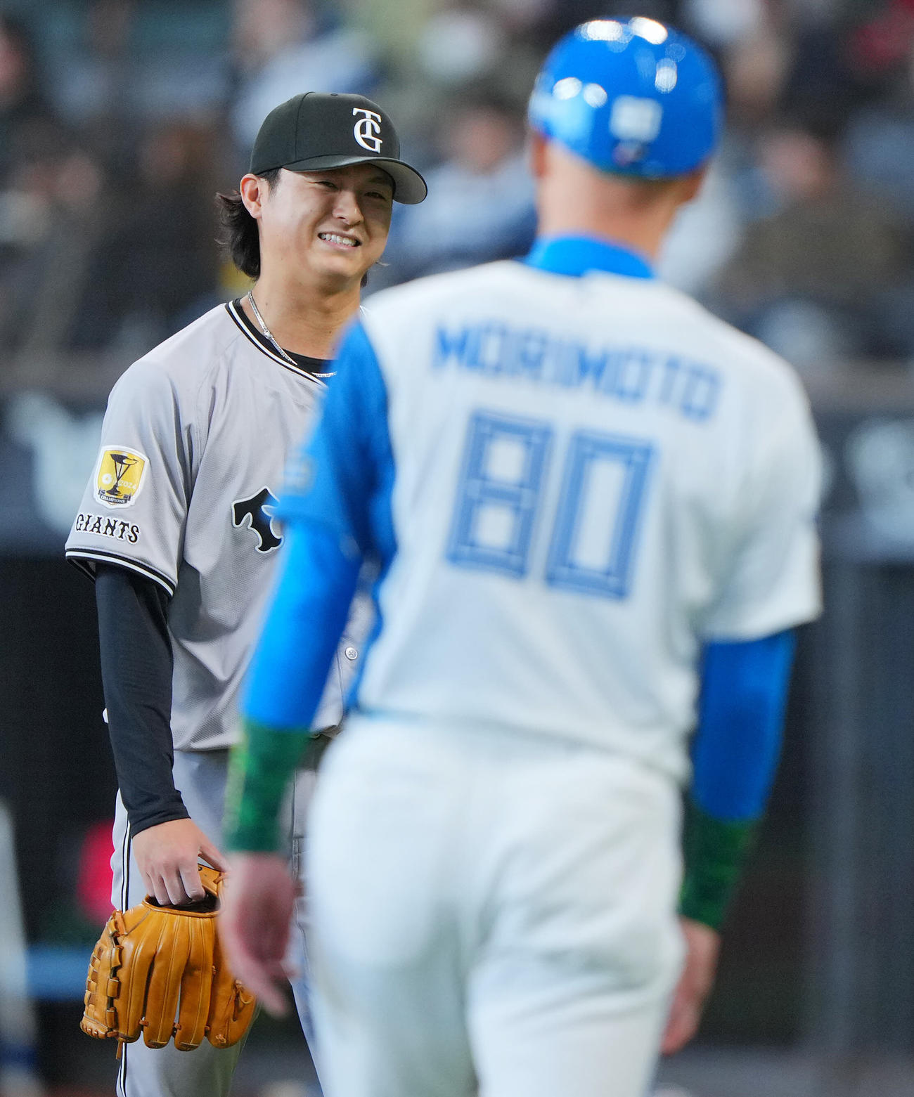 日本ハム対巨人　8回裏日本ハムの攻撃を無失点に抑えた巨人田中瑛は日本ハム森本コーチ（手前）と目を合わせ笑顔を見せる（撮影・垰建太）