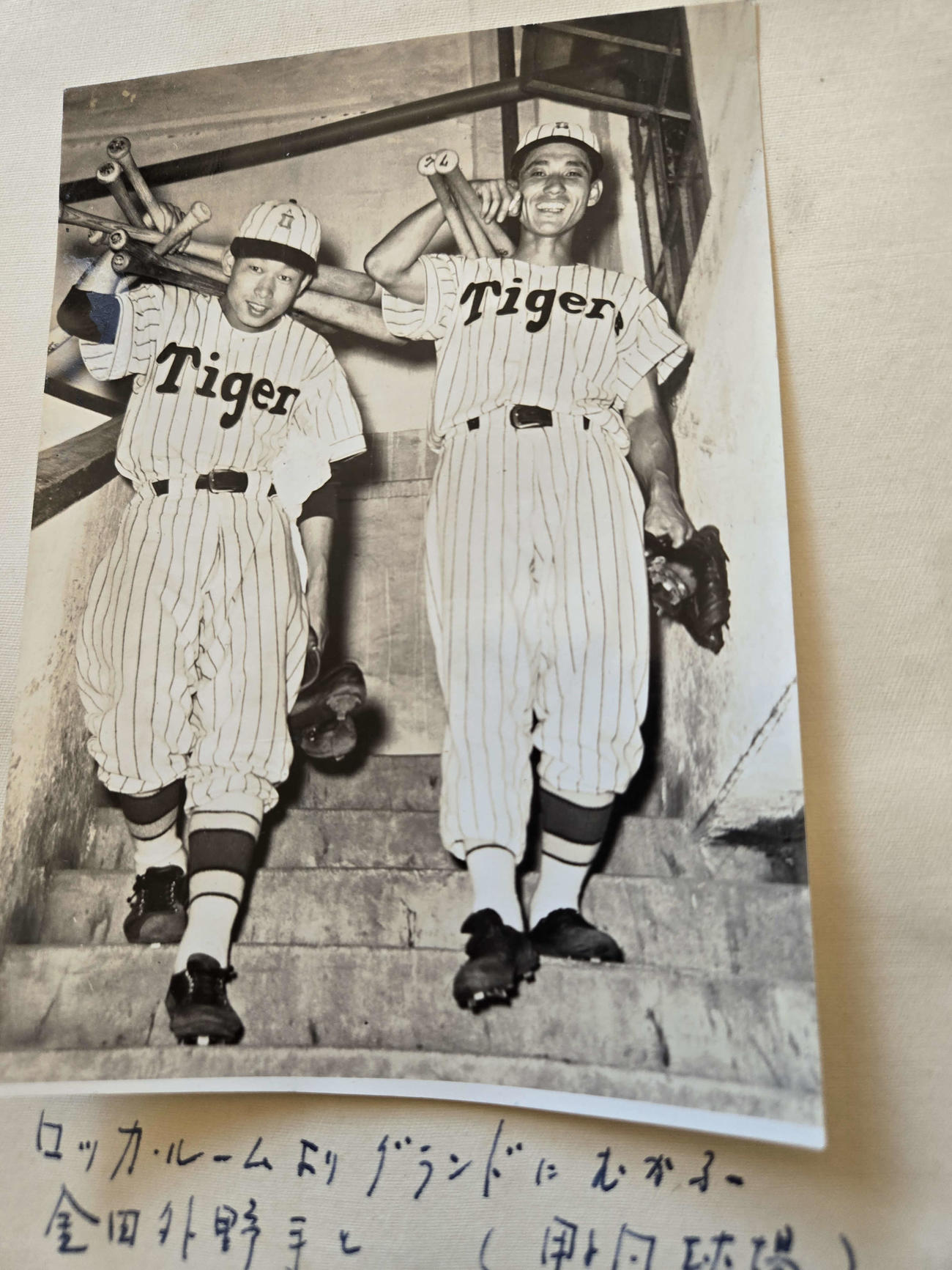甲子園球場のロッカーからバットをかついでグラウンドに向かう吉田義男氏。右は金田正泰外野手（家族提供）