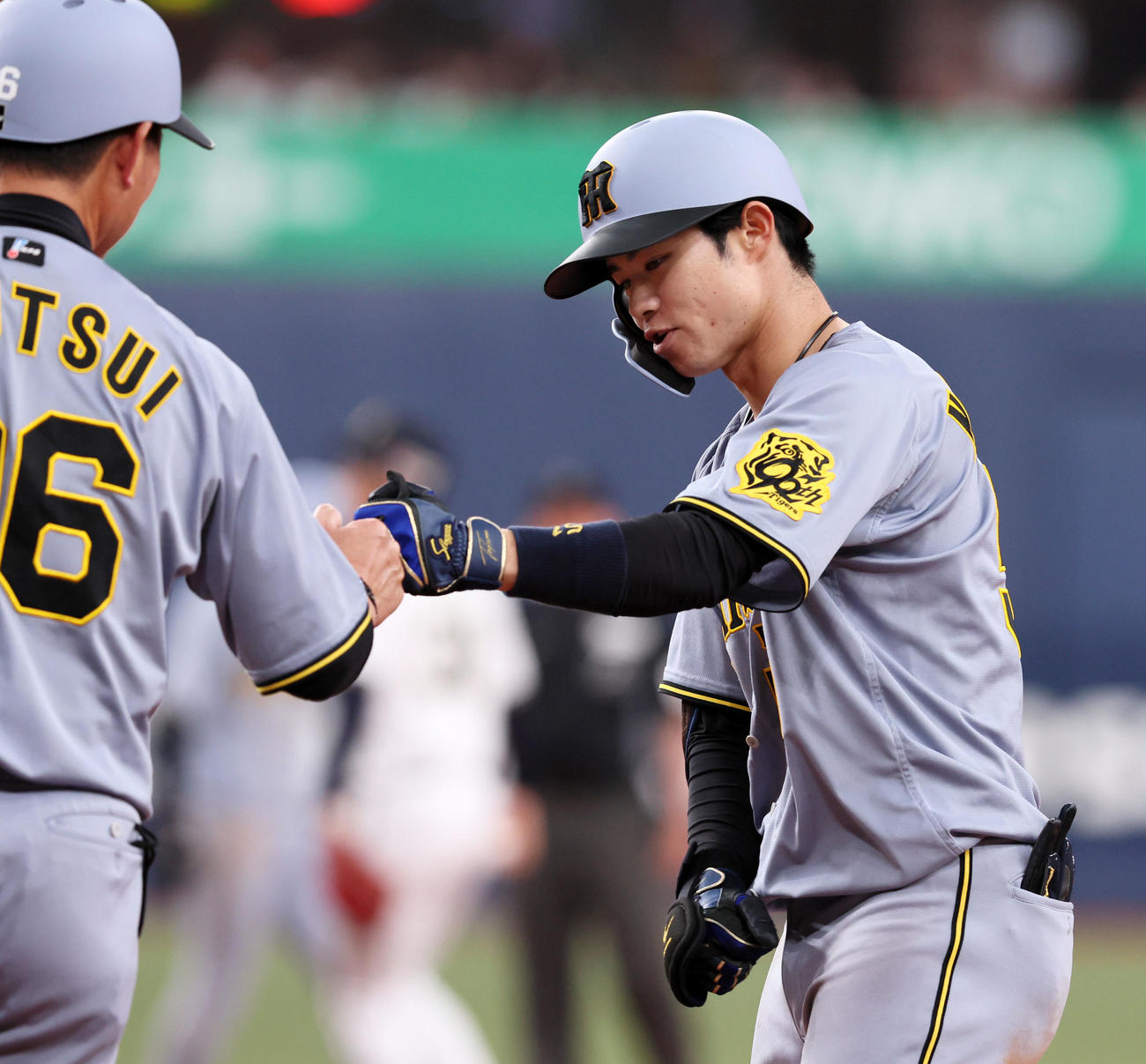 オリックス対阪神　7回表阪神1死一、三塁、中野は右前適時打を放筒井コーチ（左）とタッチする（撮影・加藤哉）