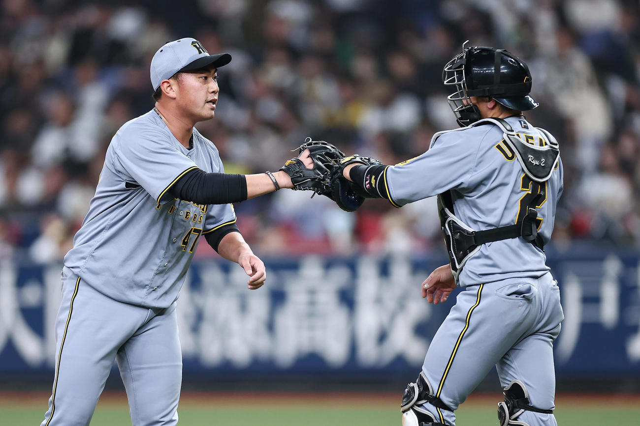 オリックス対阪神　オリックスに勝利し、グラブタッチを交わす阪神桐敷（左）と梅野（撮影・前田充）