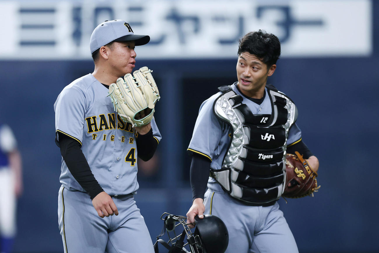 オリックス対阪神　4回裏を投げ終え、阪神坂本（右）と言葉を交わしながらベンチへ戻る村上（撮影・前田充）
