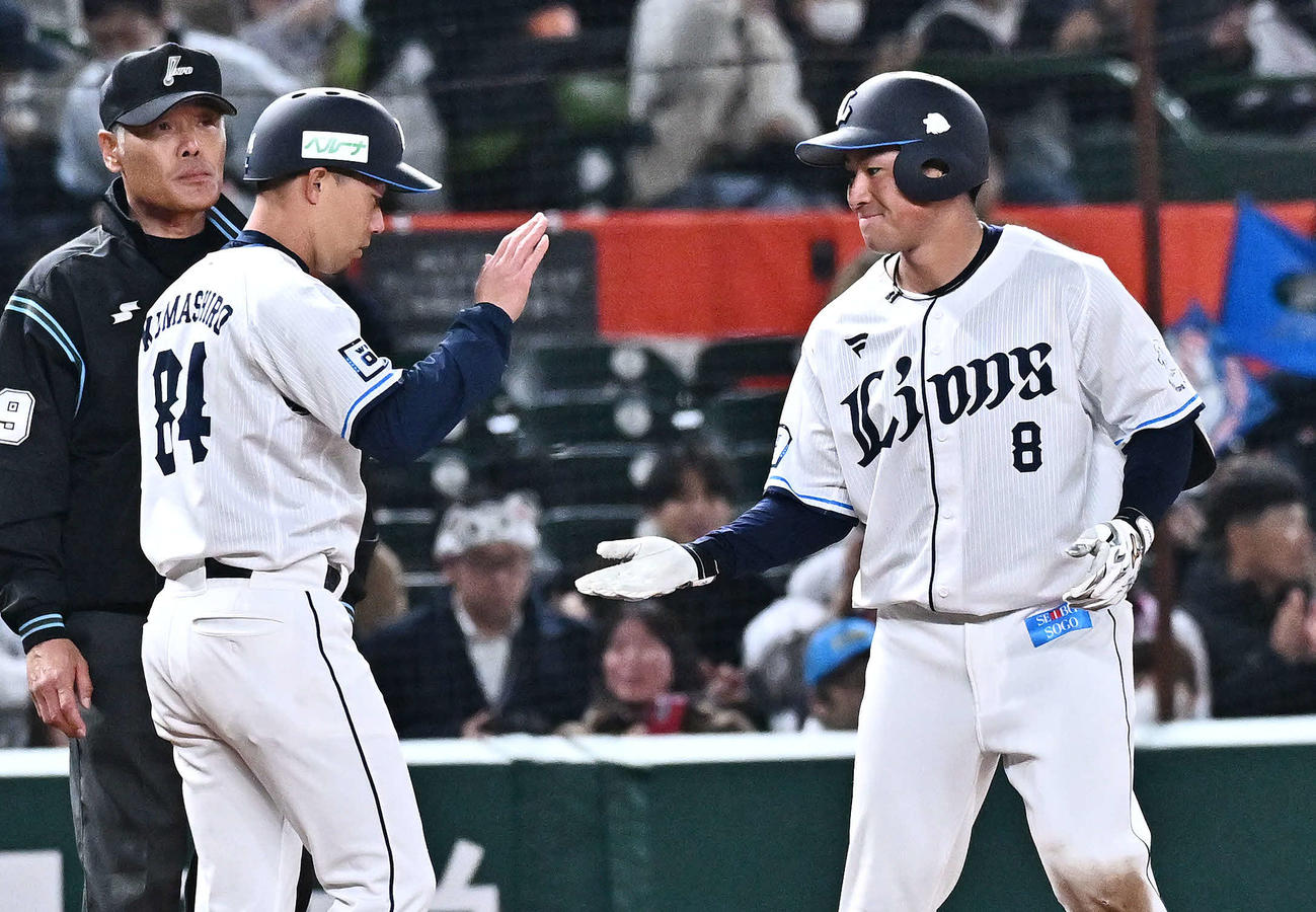 西武対DeNA 6回裏西武1死三塁、先制適時三塁打を放った渡部聖（右）は熊代コーチとタッチをかわす（撮影・滝沢徹郎）