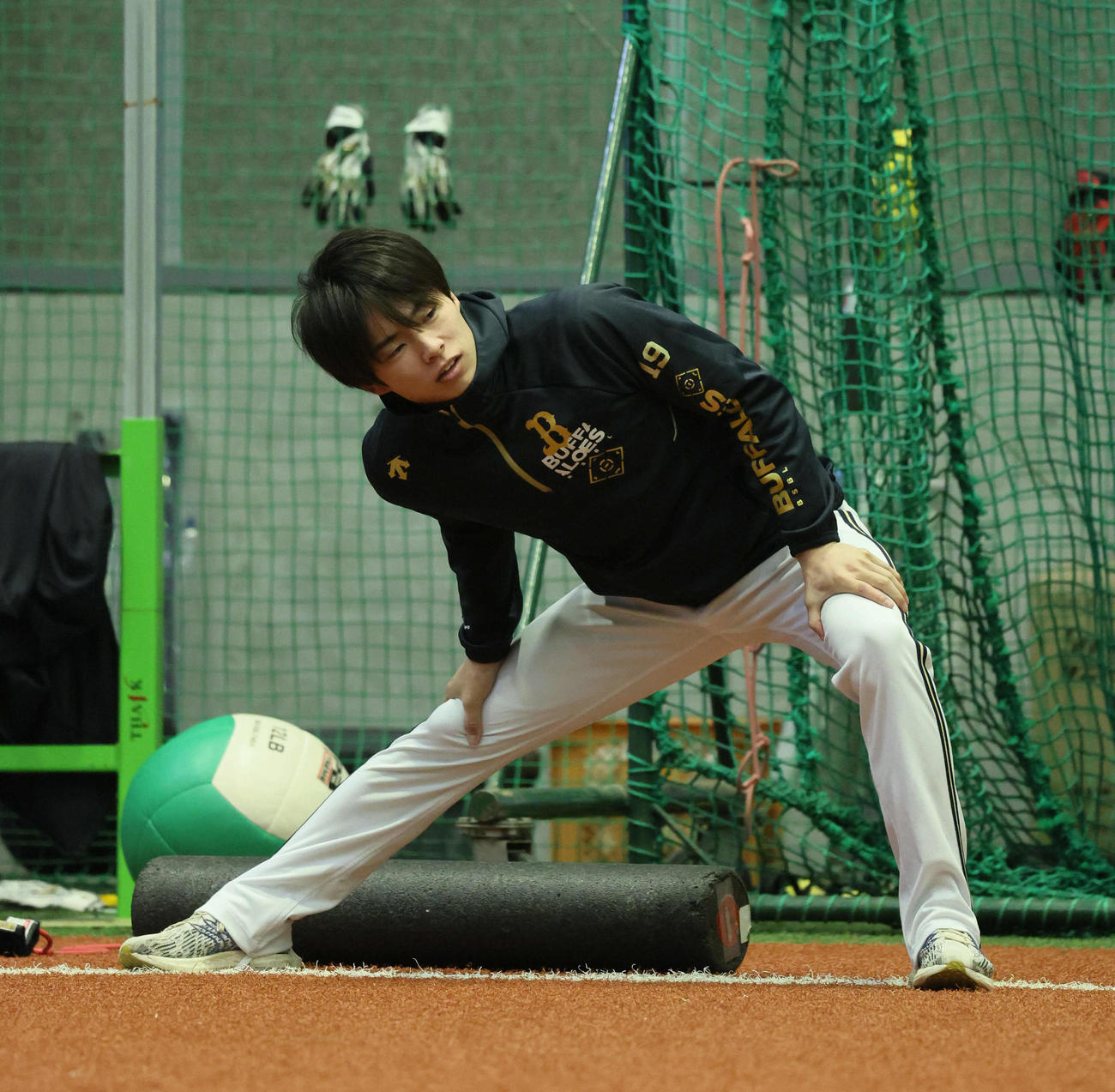 ナインが練習する室内練習場入りし、ウオームアップするオリックス山岡（撮影・宮崎幸一）