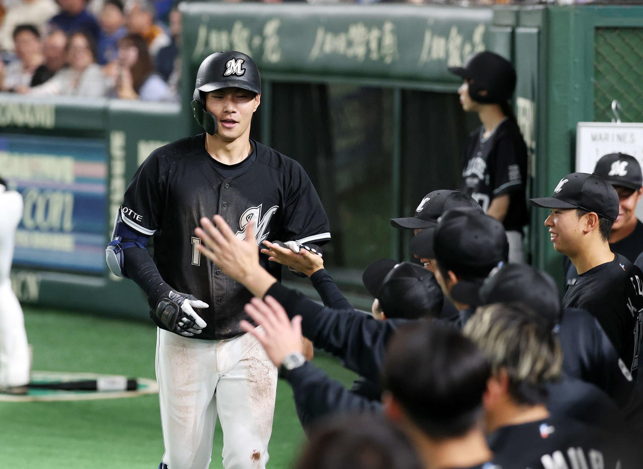 巨人対ロッテ　7回表ロッテ1死、藤原（左）は中越えランニング本塁打を放ちベンチ前でタッチ（撮影・鈴木正人）　