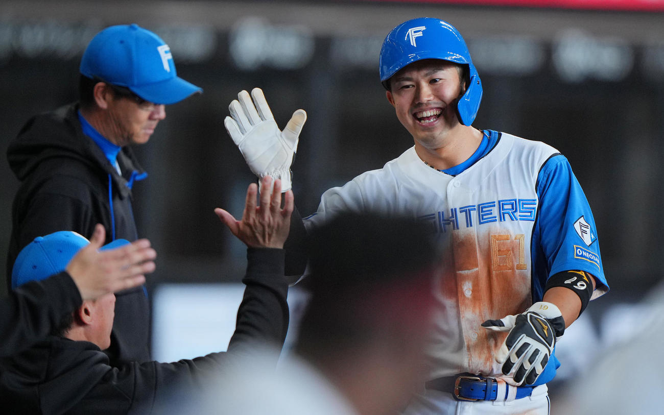 日本ハム対ヤクルト　6回裏の攻撃を終えナインの出迎えを受ける日本ハム今川（撮影・垰建太）