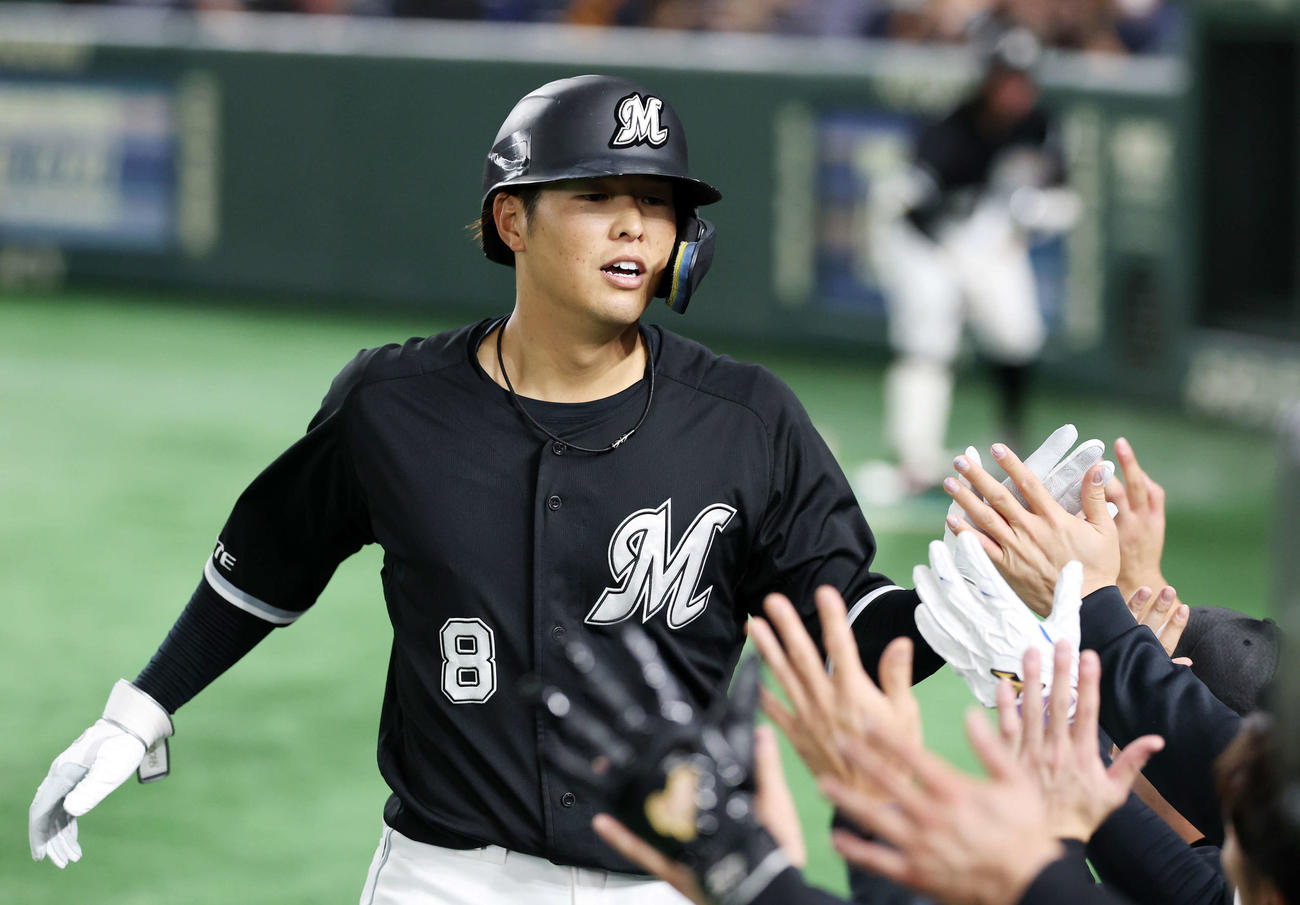巨人対ロッテ　9回表ロッテ無死、中村奨は左越えソロ本塁打を放ちベンチ前でタッチ（撮影・鈴木正人）　