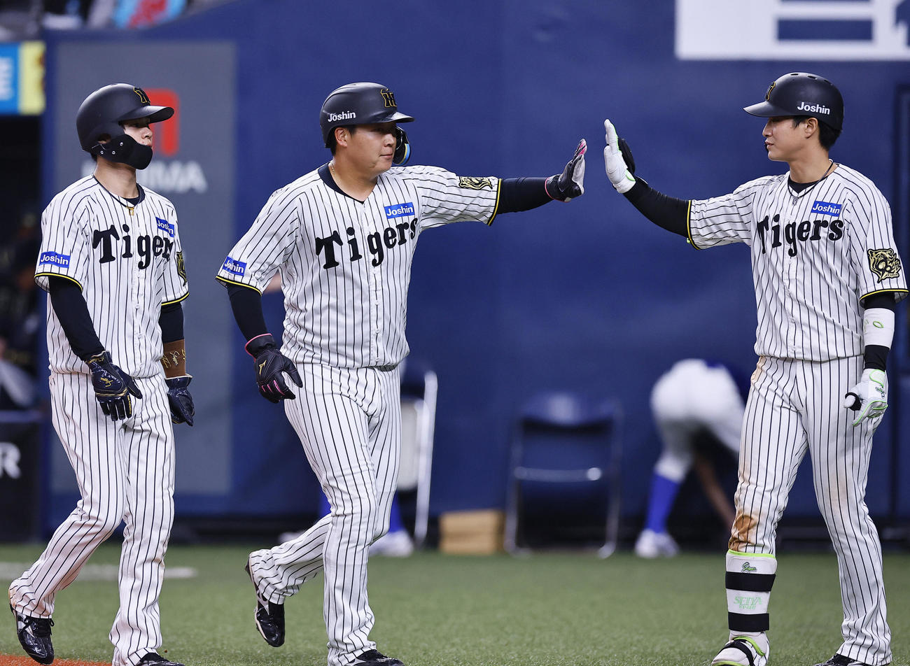 オリックス対阪神　8回に同点の適時打を放ち、木浪（右）らとタッチを交わす阪神大山（中央）（撮影・藤尾明華）