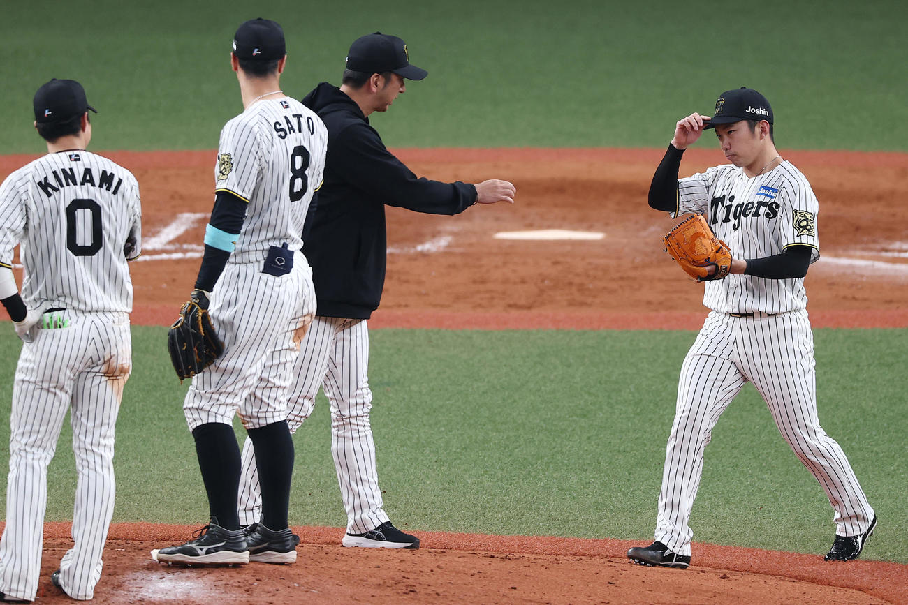 阪神対オリックス　9回表オリックス2死一、二塁、藤川監督（中央右）からボールを受け取り、マウンドに上がる石井（右）（撮影・前田充）