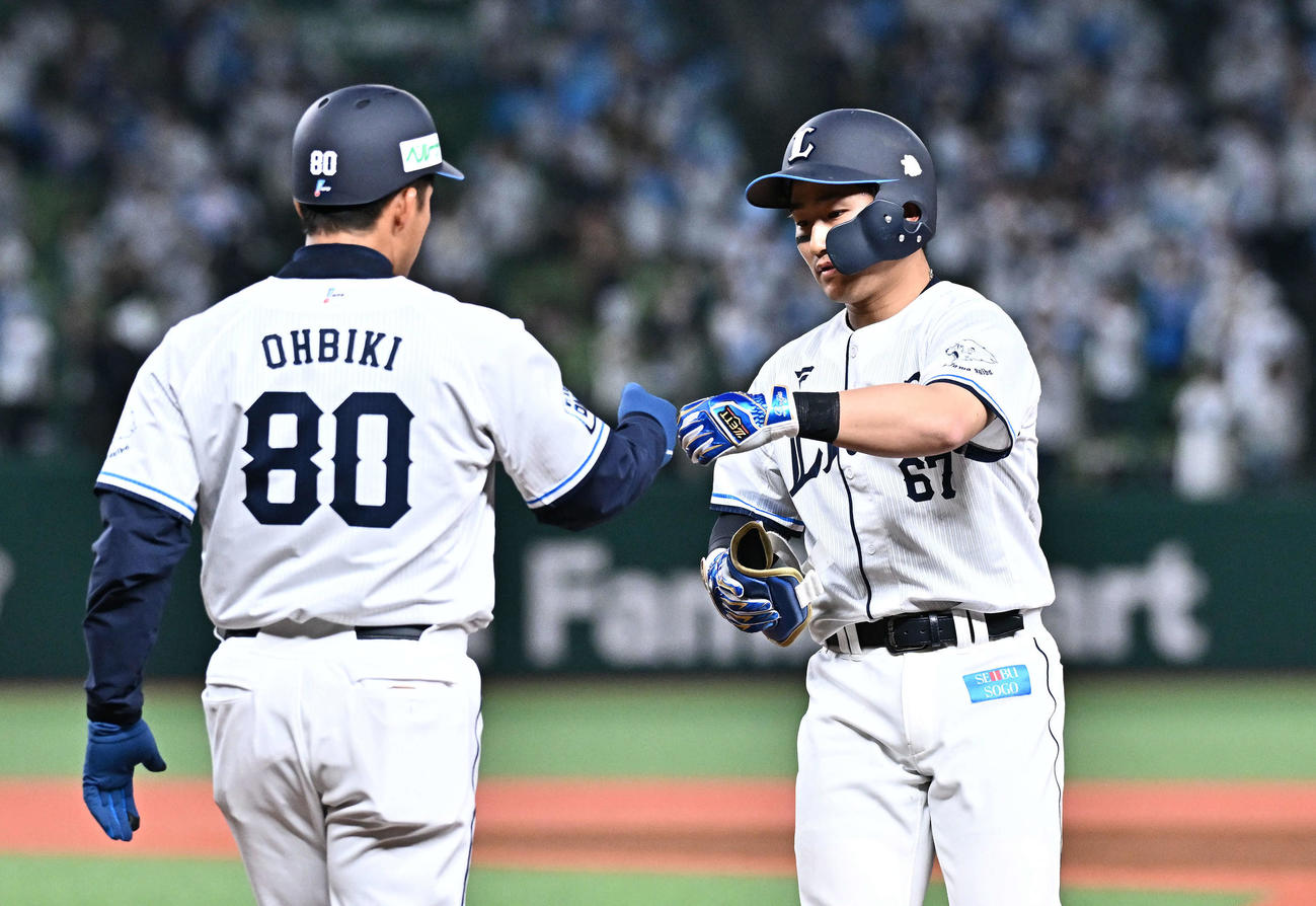 西武対DeNA 6回裏西武無死、左前打を放った野村大（右）は大引コーチとタッチをかわす（撮影・滝沢徹郎）
