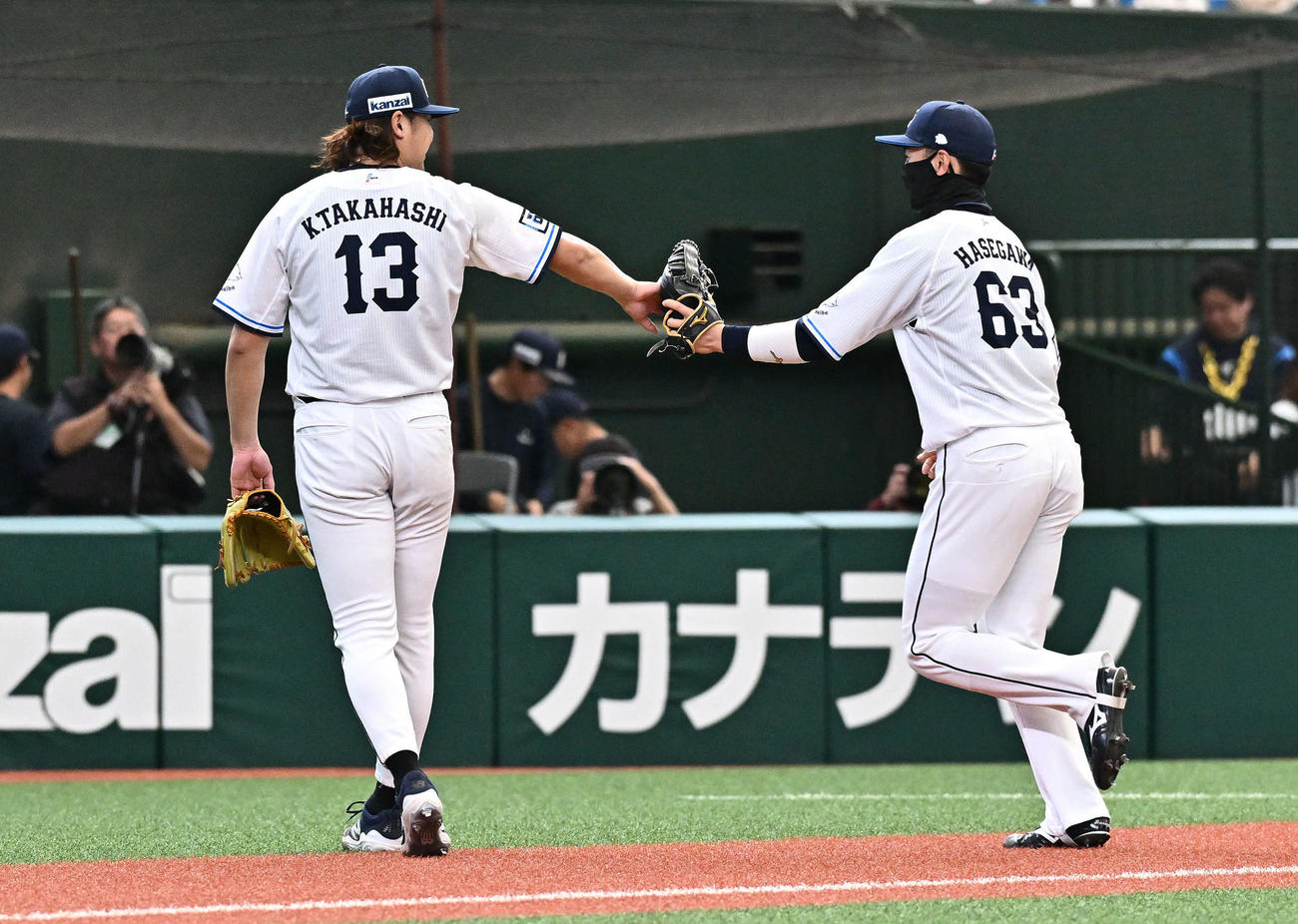 西武対DeNA 5回表を投げ終えた西武先発の高橋（左）は好守を見せた長谷川とタッチをかわす（撮影・滝沢徹郎）