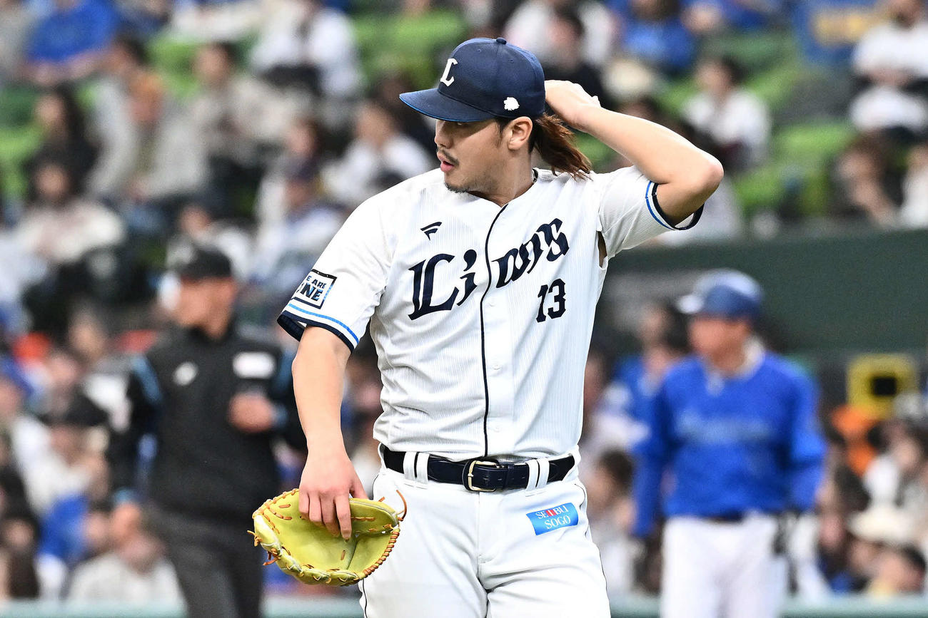 西武対DeNA 2回表を投げ終えた西武先発の高橋は長髪に触れながら引き揚げる（撮影・滝沢徹郎）