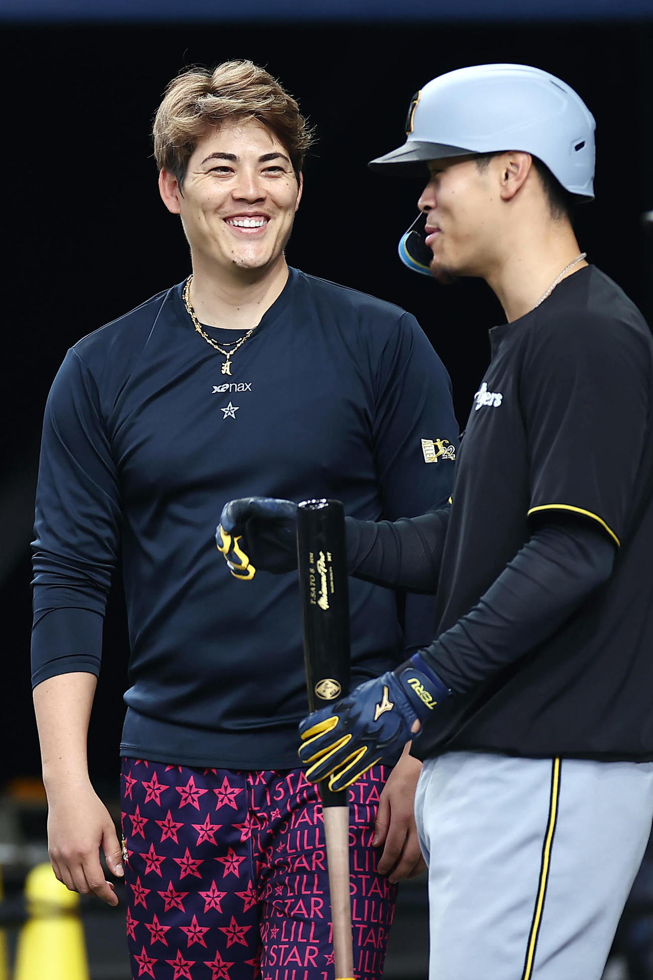 オリックス対阪神　試合前練習で阪神佐藤輝（右）と談笑するオリックス九里（撮影・前田充）