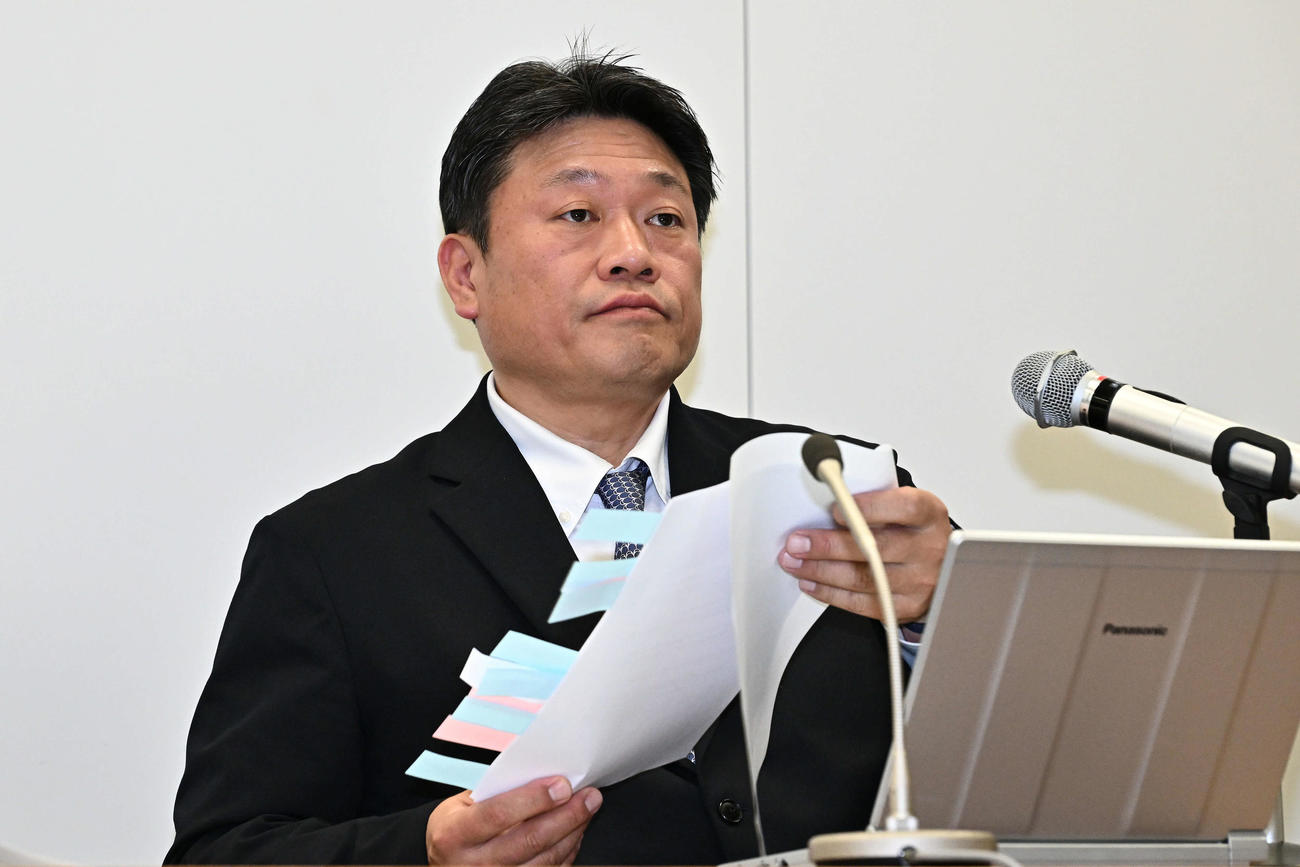 資料を手に会見するNPB中村事務局長（撮影・滝沢徹郎）