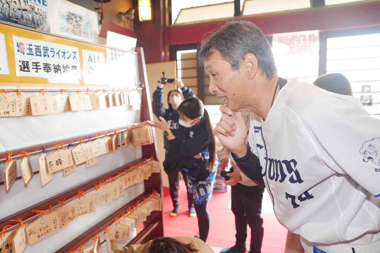 狭山山不動寺の選手、スタッフらの絵馬を見つめる西武西口監督（撮影・足立雅史）