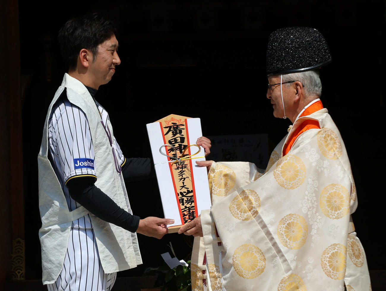 広田神社に必勝祈願した阪神藤川監督（左）は西井璋宮司から必勝守護のお札を受け取る（撮影・西尾就之）
