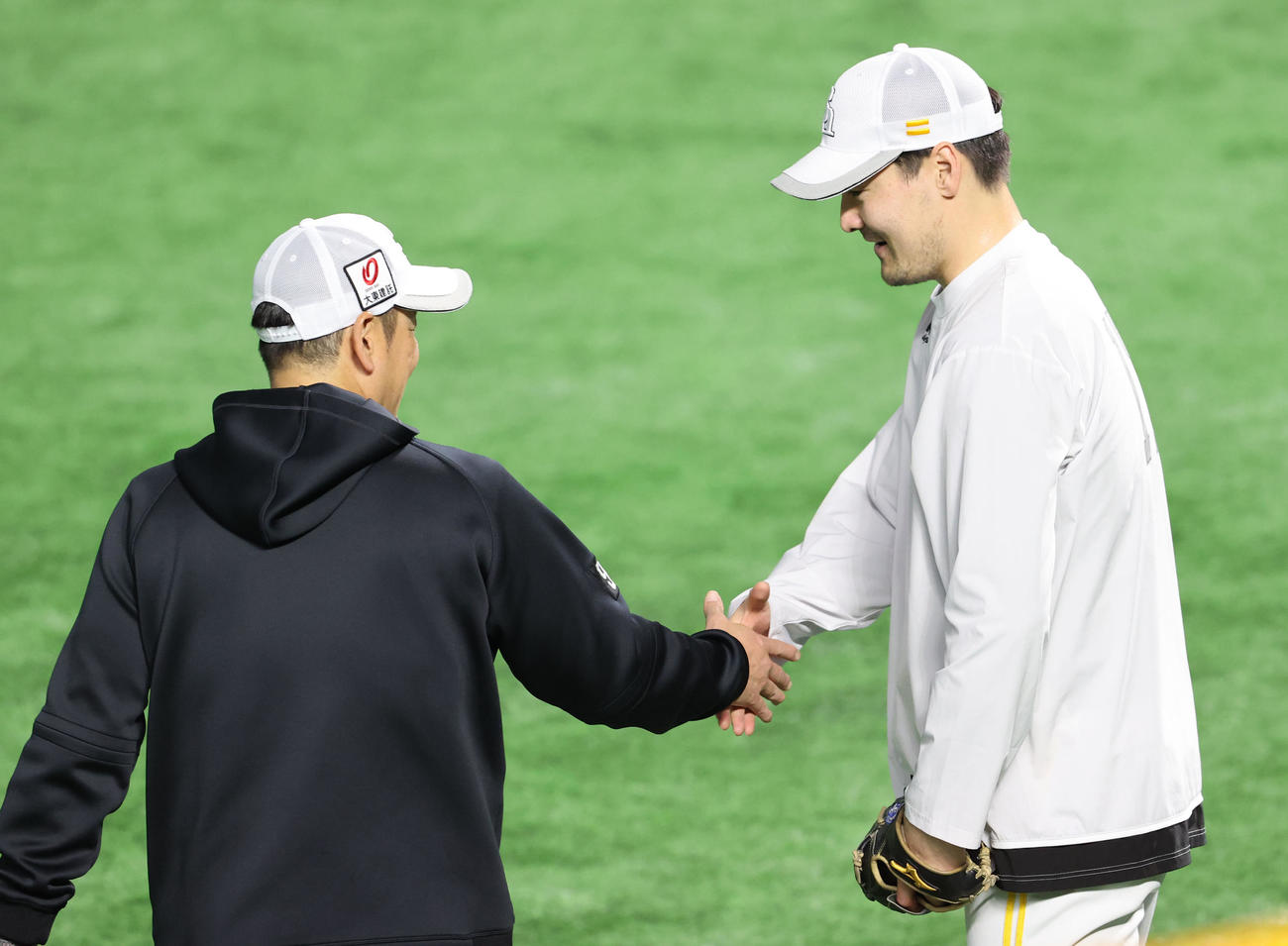 キャッチボールを終えた有原は倉野コーチと握手を交わす（撮影・梅根麻紀）