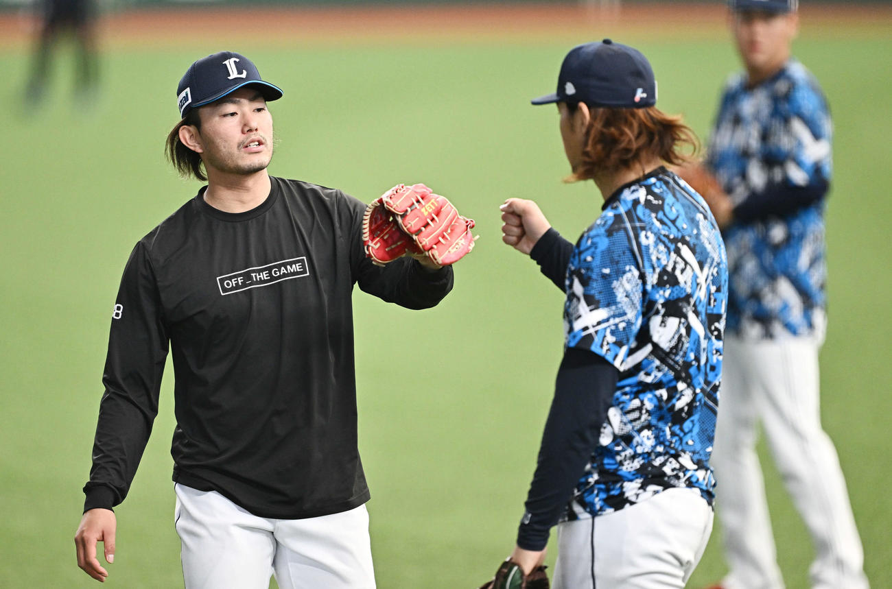 キャッチボールを終えタッチをかわす西武今井（左）と高橋（撮影・滝沢徹郎）