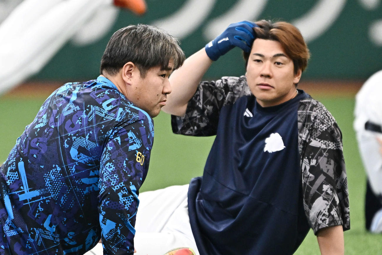 ウオーミングアップする西武中村剛（左）と炭谷（撮影・滝沢徹郎）