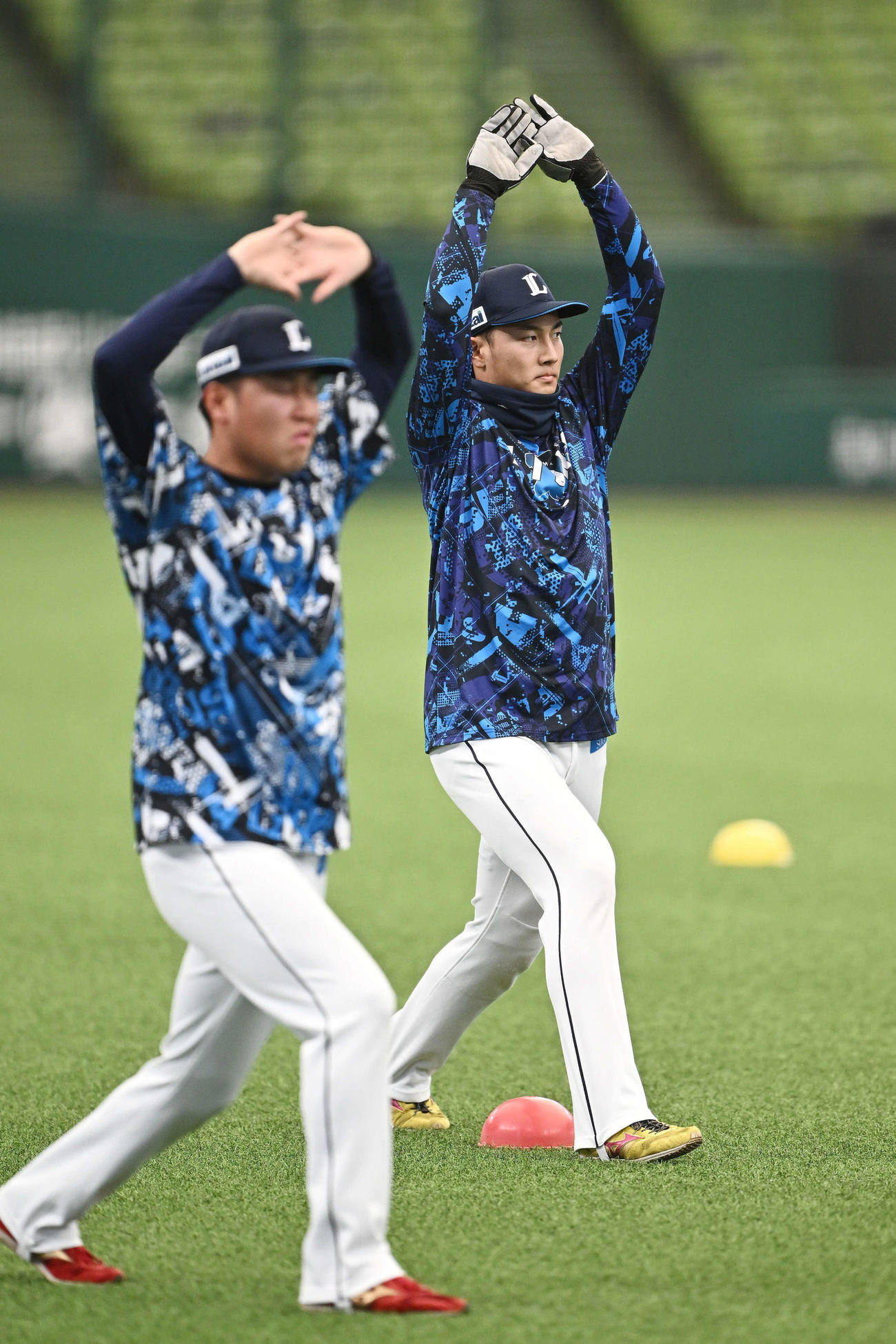ウオーミングアップする西武長谷川（後方）（撮影・滝沢徹郎）