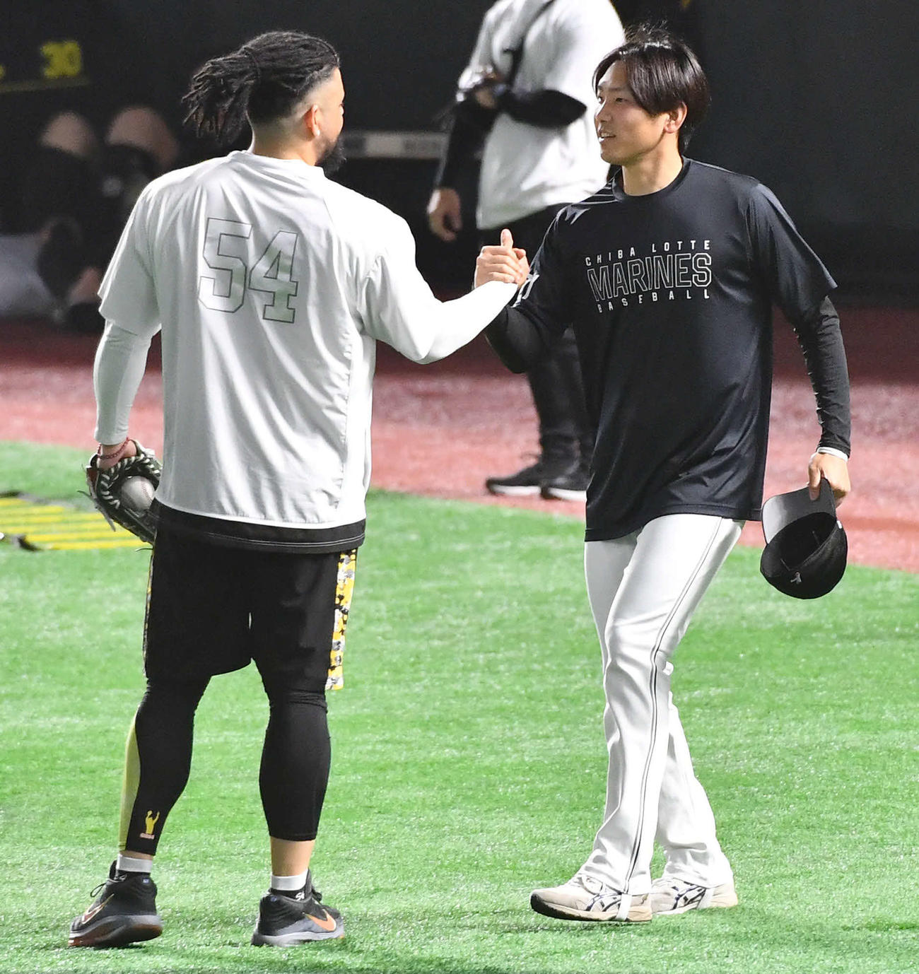 ソフトバンク対ロッテ　試合前、ソフトバンクのオスナ（左）と握手を交わすロッテ石川柊（撮影・岩下翔太）