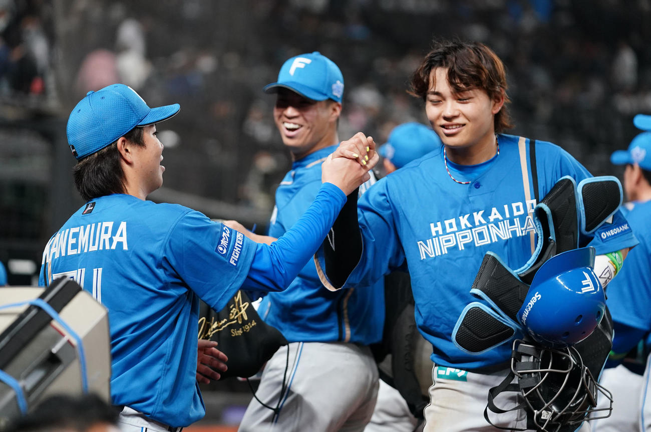 西武対日本ハム　開幕戦を完封勝利で飾り笑顔をでタッチを交わす日本ハム金村（左）と田宮（撮影・横山健太）