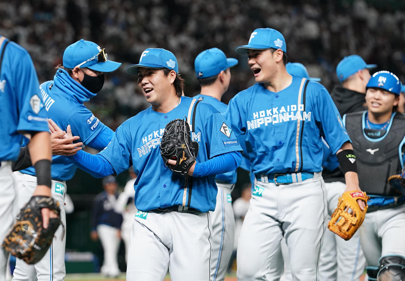 西武対日本ハム　開幕戦を完封勝利で飾り笑顔でタッチを交わす、左から日本ハム新庄監督、金村、清宮、田宮（撮影・横山健太）