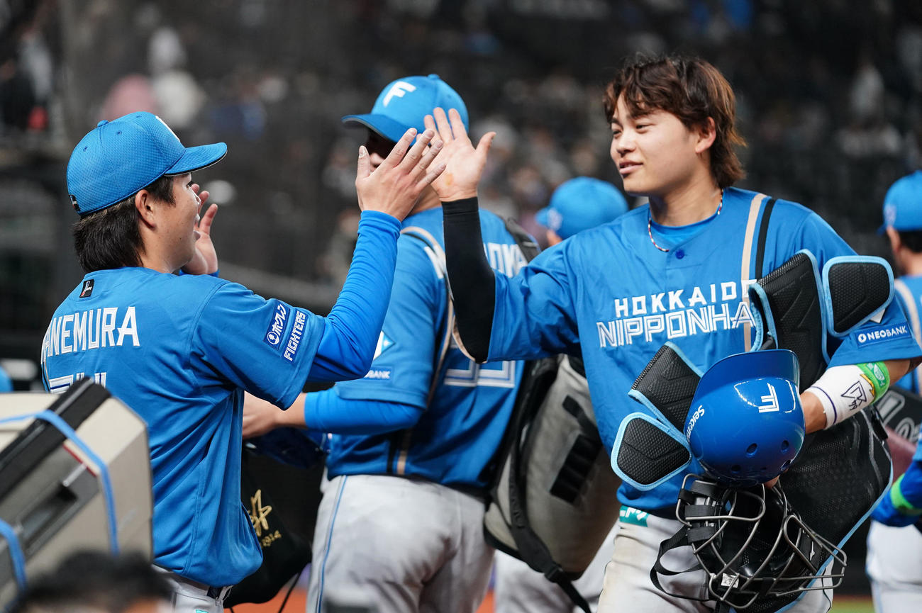 西武対日本ハム　開幕戦を完封勝利で飾り笑顔をでタッチを交わす日本ハム金村（左）と田宮（撮影・横山健太）