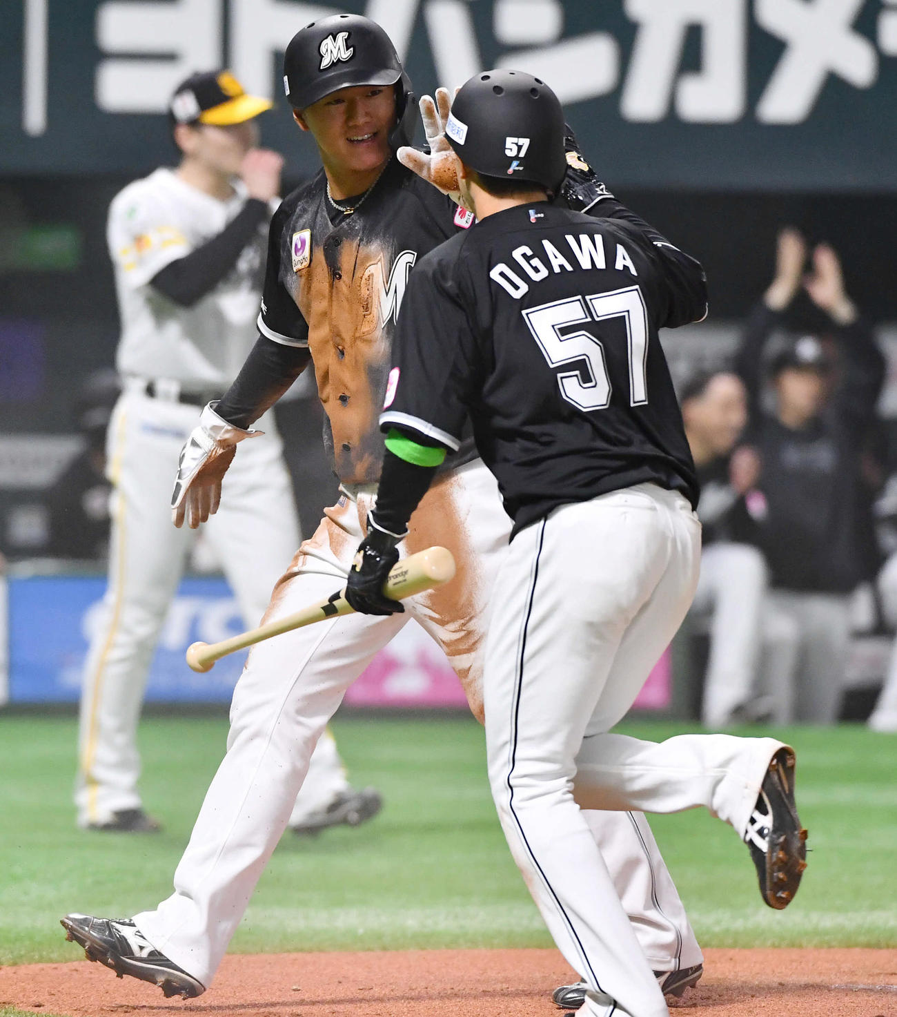 ソフトバンク対ロッテ　6回表ロッテ1死二、三塁、藤原の右前2点適時打で生還した西川（左）は小川と笑顔でタッチを交わす（撮影・岩下翔太）