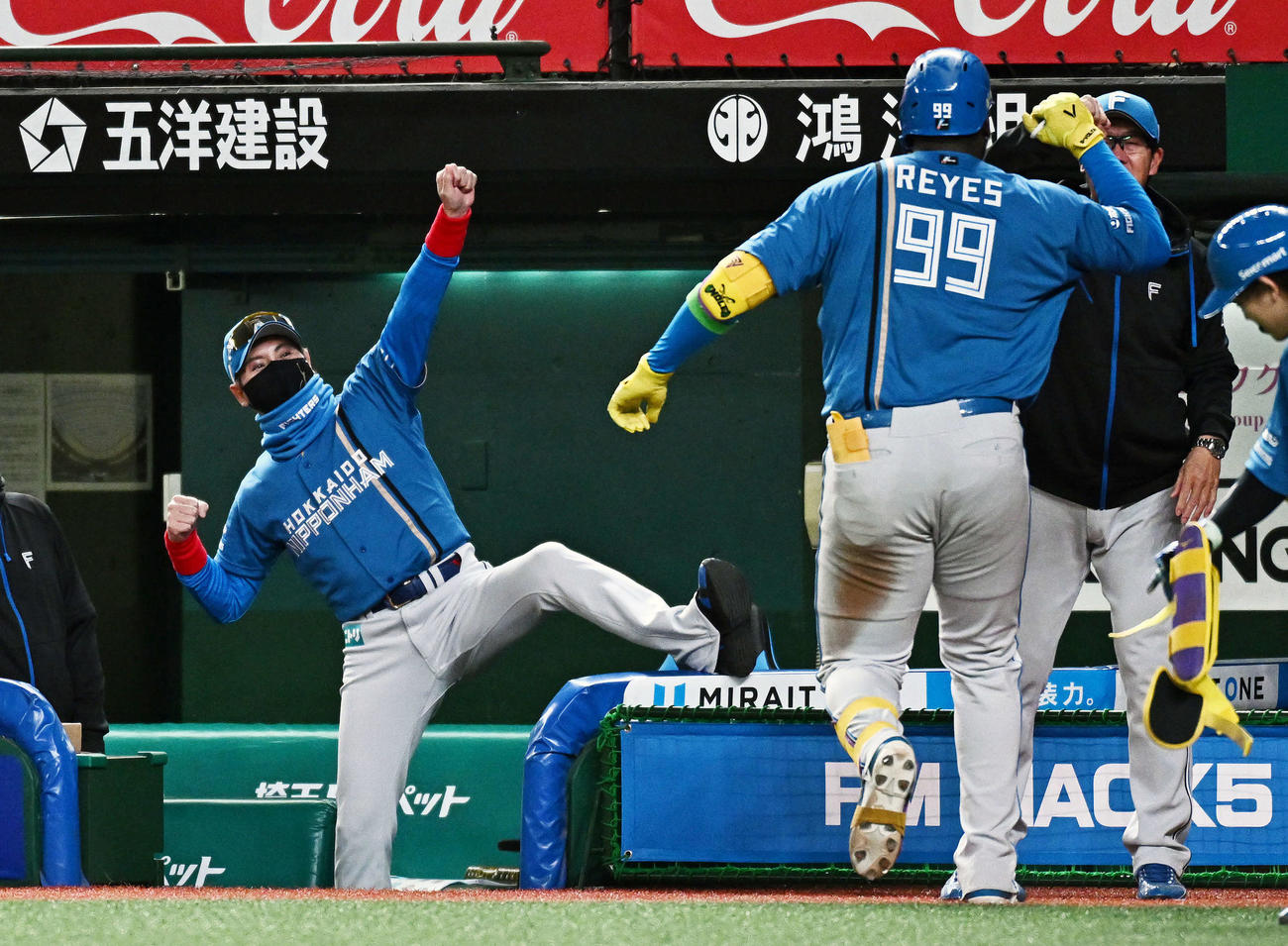 西武対日本ハム　9回表日本ハム2死、ソロ本塁打を放ったレイエス（手前右）を迎える新庄監督（撮影・滝沢徹郎）