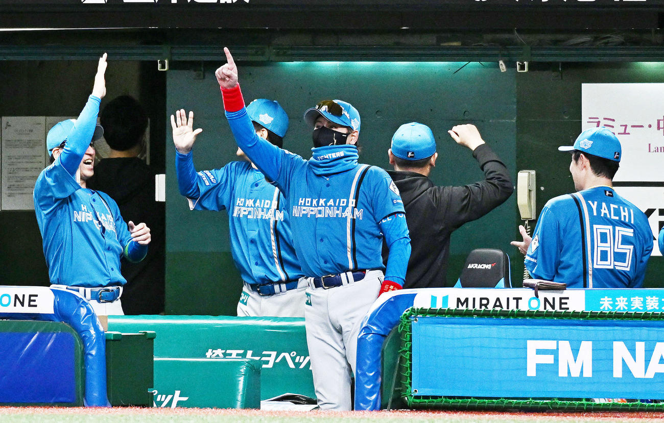 西武対日本ハム　開幕戦で勝利を飾り人さし指を突き上げる日本ハム新庄監督（中央）（撮影・滝沢徹郎）