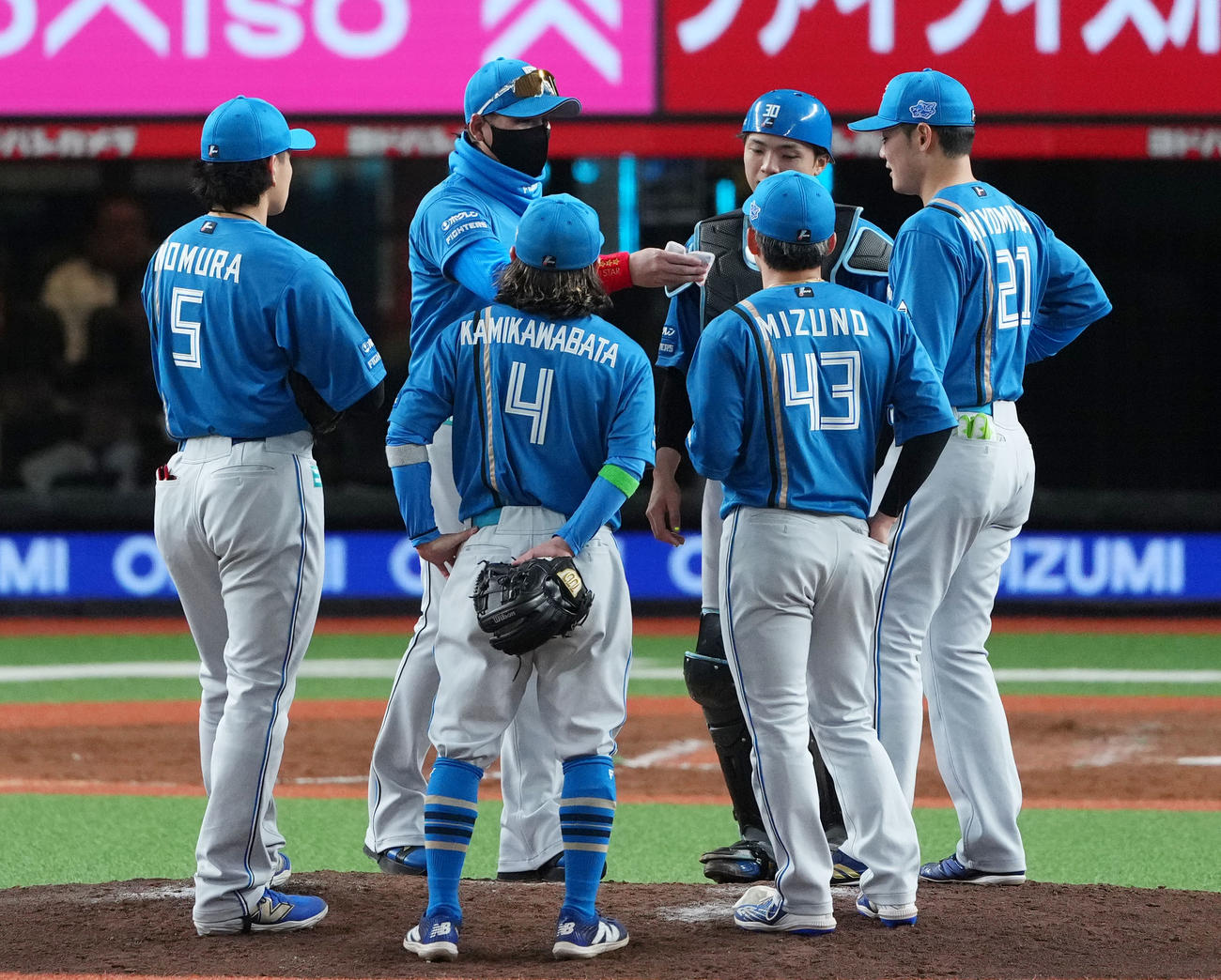 西武対日本ハム　8回裏途中、マウンドに向かった日本ハム新庄監督（左から2人目）は清宮幸（右）にカイロを手渡す（撮影・横山健太）