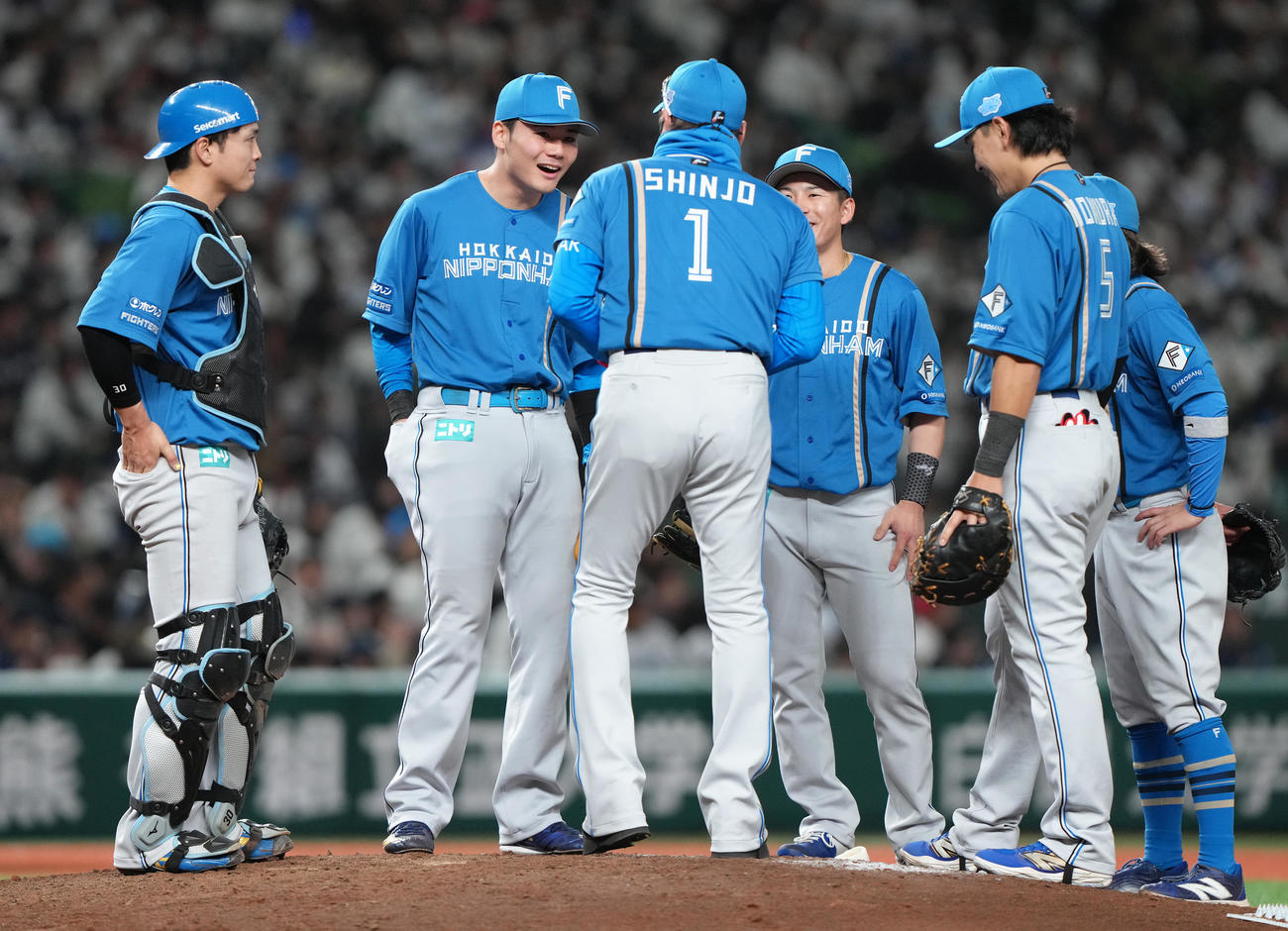 西武対日本ハム　8回、日本ハム新庄監督（中央）からカイロを受け取り、ズボンのポケットに入れる清宮幸（同左）（撮影・足立雅史）