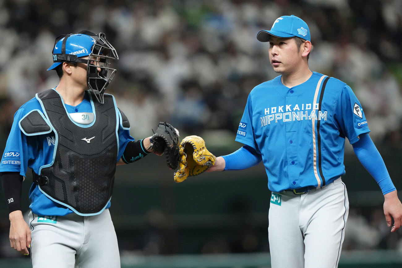 西武対日本ハム　2回裏西武の攻撃を3者凡退に抑えた日本ハム加藤貴（右）は郡司とタッチを交わす（撮影・足立雅史）