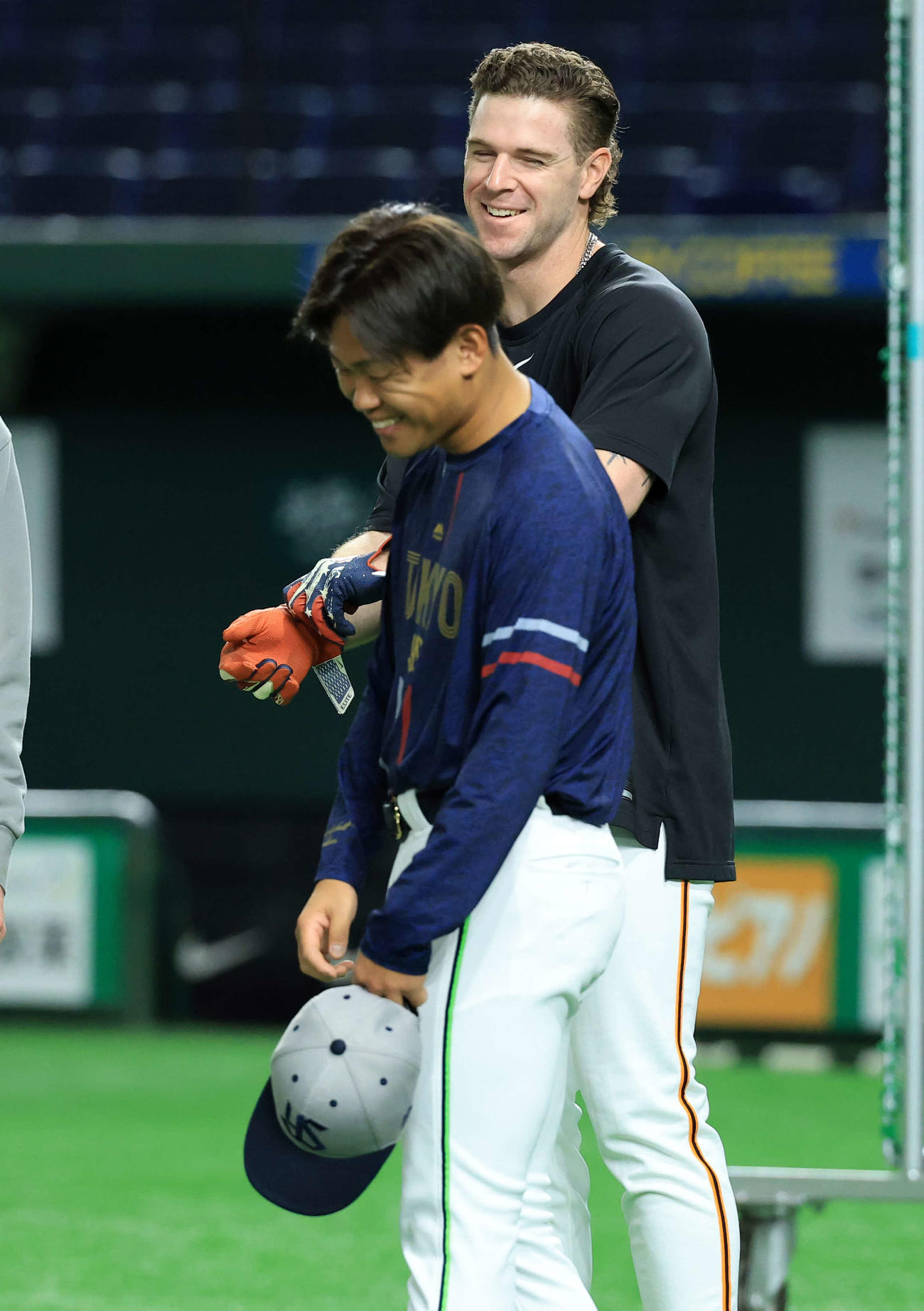 巨人対ヤクルト　試合前練習中、ヤクルト田口〔手前）から前日の死球を謝罪され笑顔で返す巨人キャベッジ（撮影・浅見桂子）