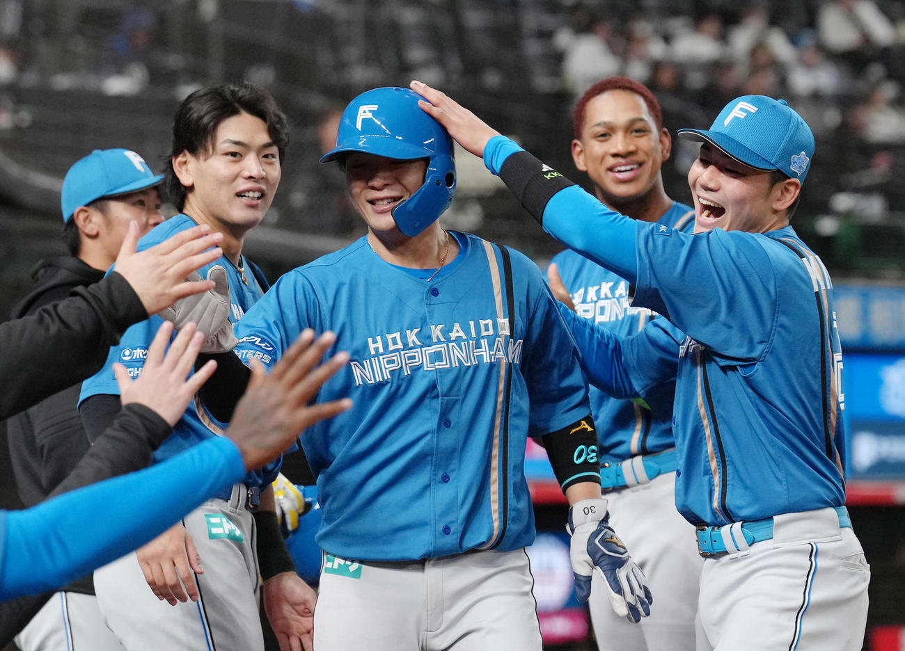 西武対日本ハム　10回表日本ハム2死二、三塁、上川畑の適時打で生還した郡司（中央）は清宮幸（右端）らに祝福される（撮影・足立雅史）