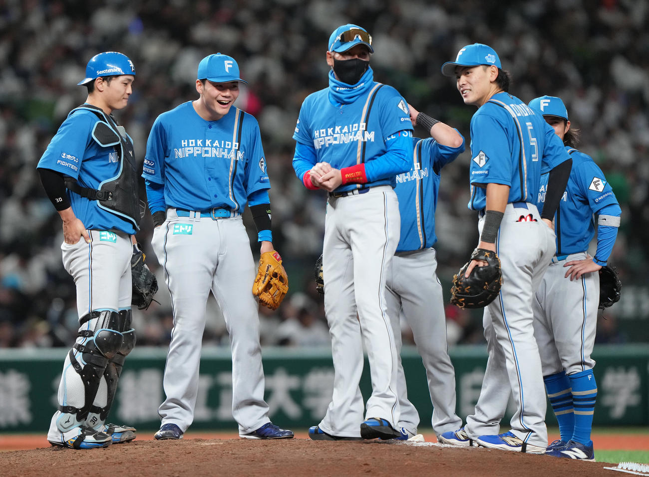 西武対日本ハム　8回、マウンドでの日本ハム新庄監督（中央）の話に笑顔を見せる、左から郡司、清宮幸、1人おいて野村（撮影・足立雅史）