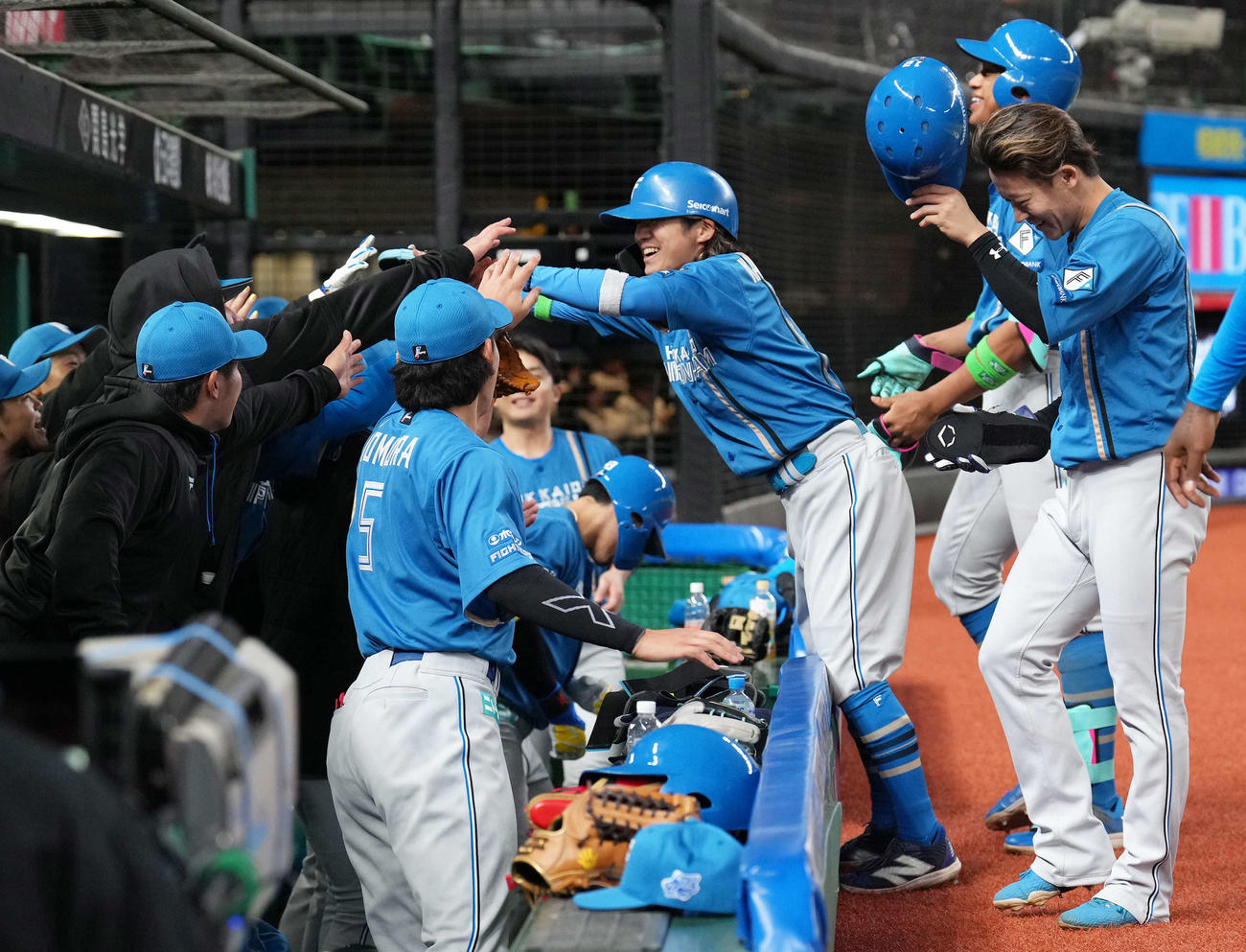 西武対日本ハム　10回、勝ち越し打を放った日本ハム上川畑（中央）はナインにタッチで迎えられる（撮影・足立雅史）