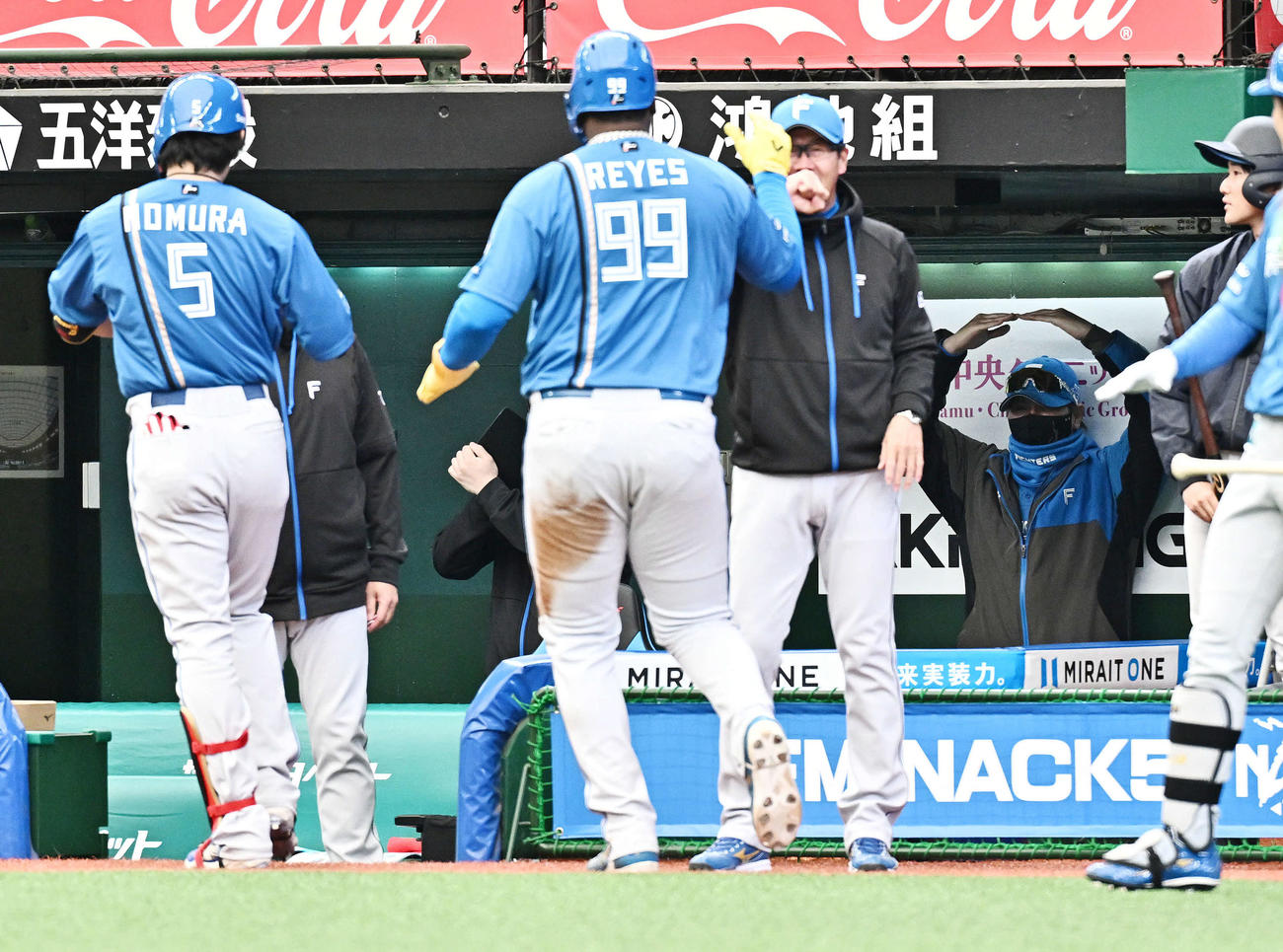 西武対日本ハム　5回表日本ハム2死二塁、2点本塁打を放った野村（手前左）に○ポーズを送る新庄監督（後方右）（撮影・滝沢徹郎）