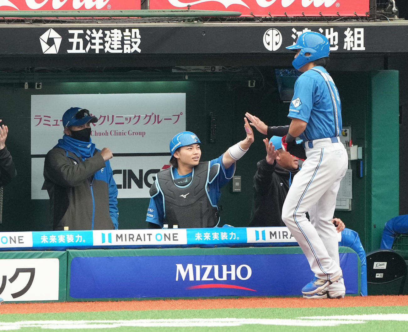 西武対日本ハム　1回、先制適時打の日本ハム野村（右）はベンチに戻り田宮（中央）とタッチを交わす。左は新庄監督（撮影・足立雅史）