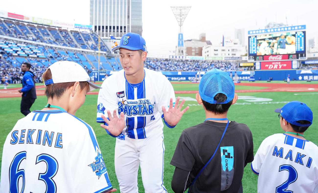 DeNA対中日　試合後、ファンとタッチを交わすDeNA松尾（中央左）（撮影・江口和貴）