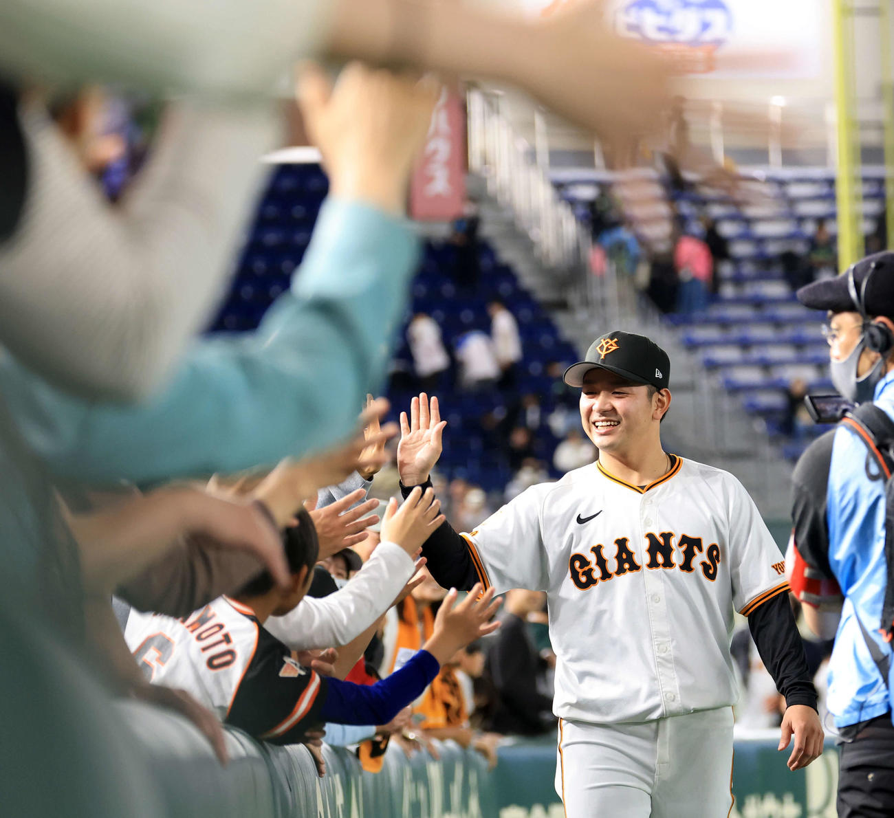 巨人対ヤクルト　プロ初勝利を挙げた巨人石川は笑顔でファンとハイタッチ（撮影・浅見桂子）