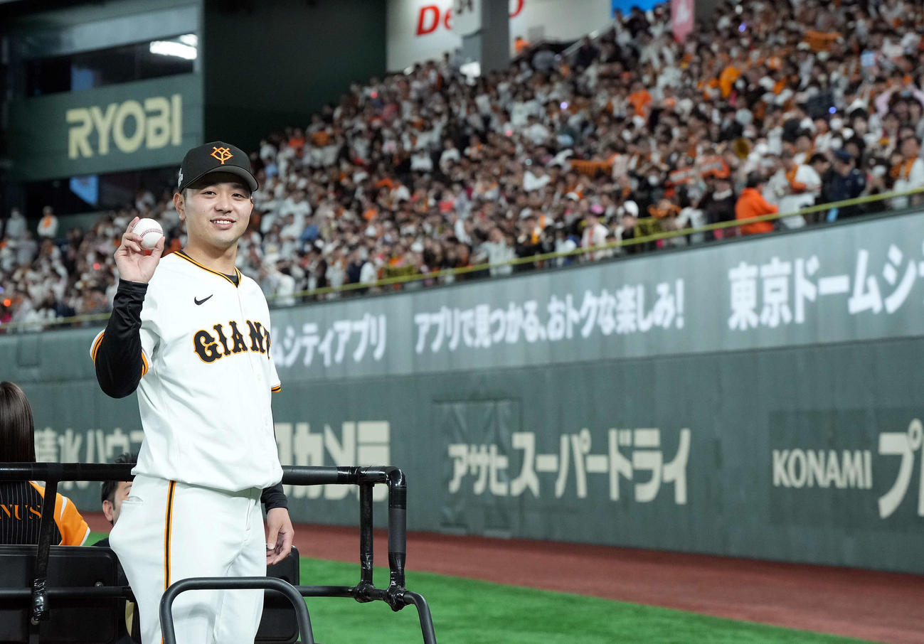 巨人対ヤクルト　プロ初勝利を飾り応援団を背に記念撮影に納まる巨人石川（撮影・たえ見朱実）